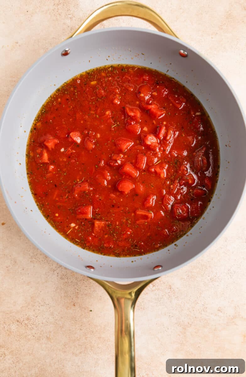 Quick and Easy 15 Minute Tomato Basil Gnocchi 4 Tomatoes, broth, garlic, and seasoning being added to a skillet.