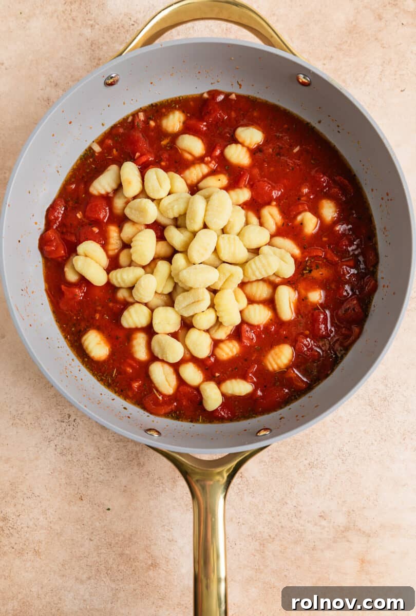 Quick and Easy 15 Minute Tomato Basil Gnocchi 5 Gnocchi added to the simmering tomato mixture in a skillet.