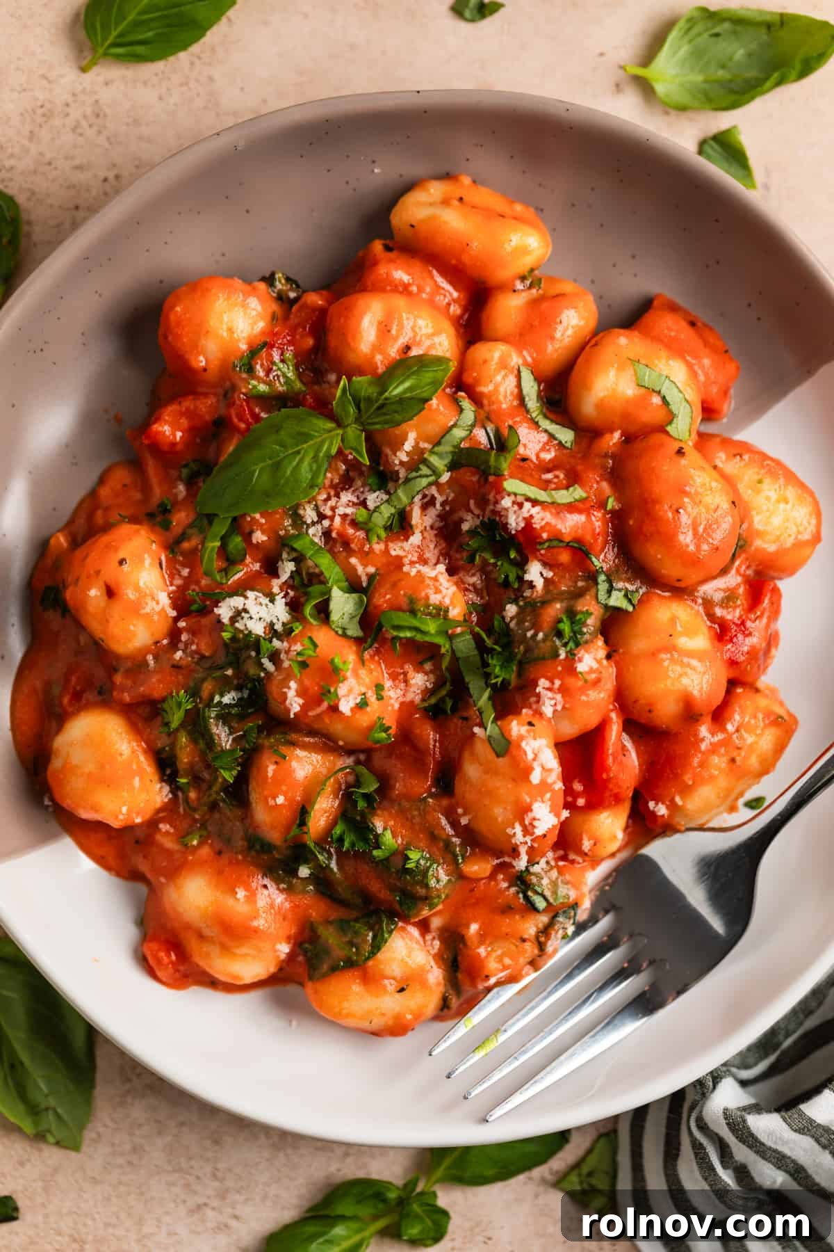 Quick and Easy 15 Minute Tomato Basil Gnocchi 9 Plate with 15-minute tomato gnocchi topped with chopped basil, parsley, and Parmesan.