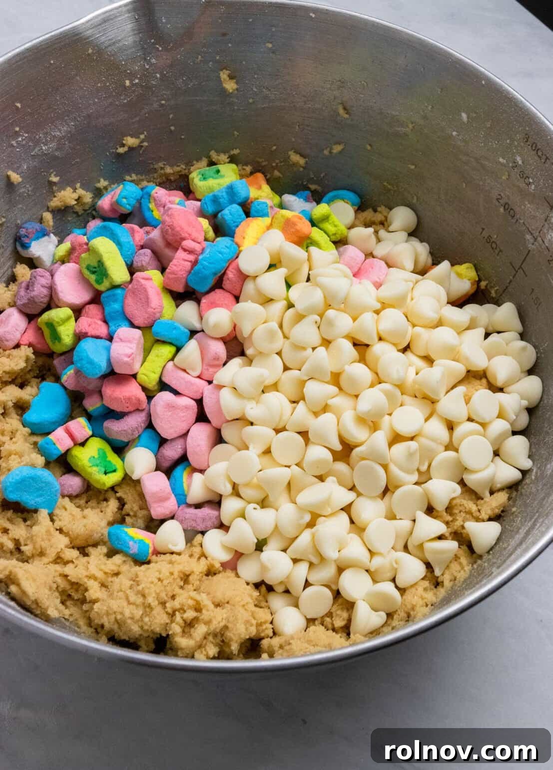 Charmed Bites 8 The vibrant addition of white chocolate chips and colorful mini marshmallows being gently folded into the prepared cookie dough, creating a visually appealing mixture.