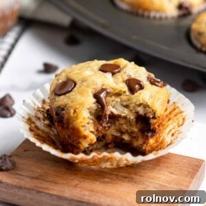 A moist and flavorful Banana Coconut Muffin with a bite taken, revealing its tender interior and delectable coconut flakes.