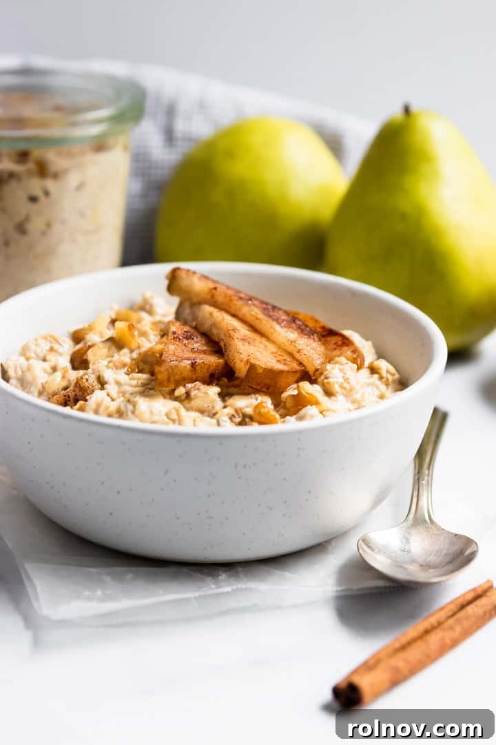 Fragrant Spiced Pear and Walnut Overnight Oats 4 Cinnamon pears on top of oatmeal in white bowl. A healthy overnight oats breakfast idea.