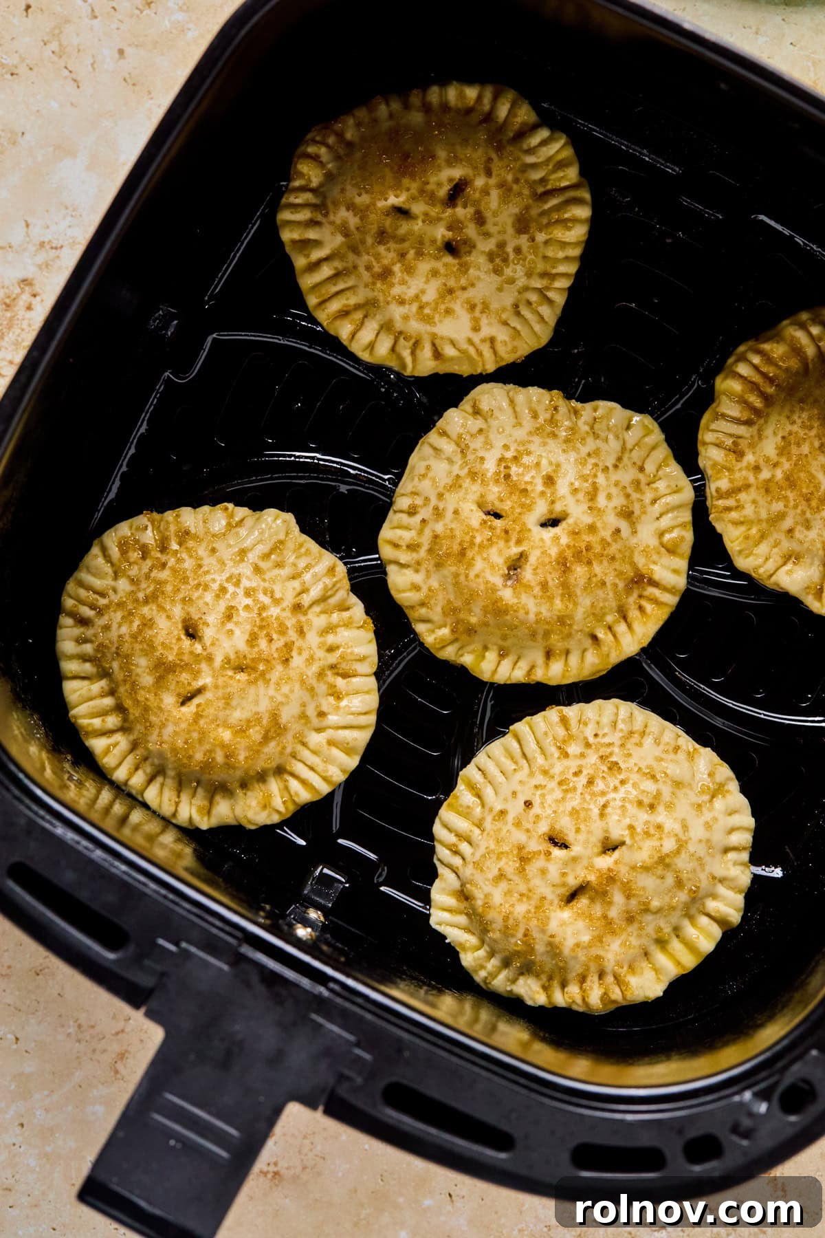 Crispy Air-Fried Blueberry Turnovers 15 Assembled blueberry hand pies neatly arranged in an air fryer basket, pre-cooking.