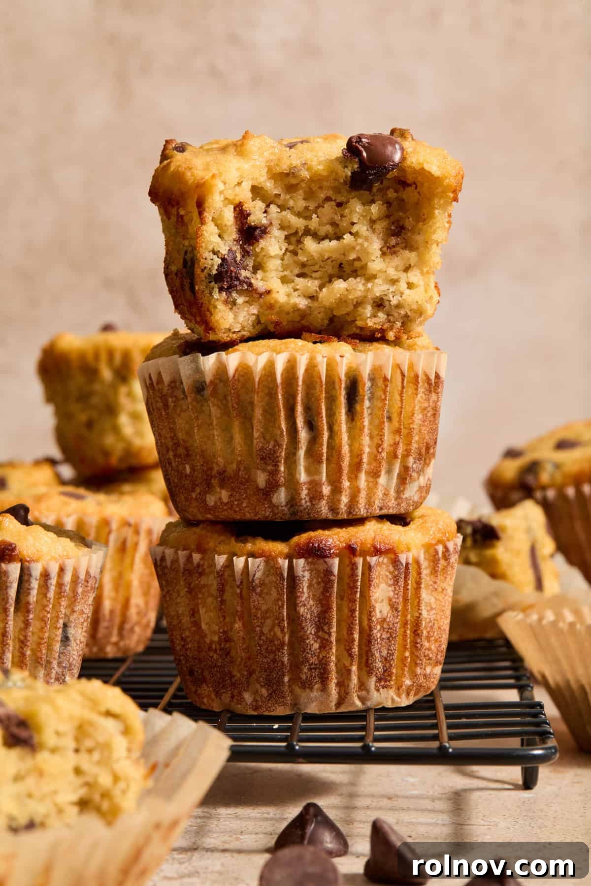 Tender Almond Banana Muffins 5 Stack of almond flour banana bread muffins with chocolate chips with bite taken out of top muffin.
