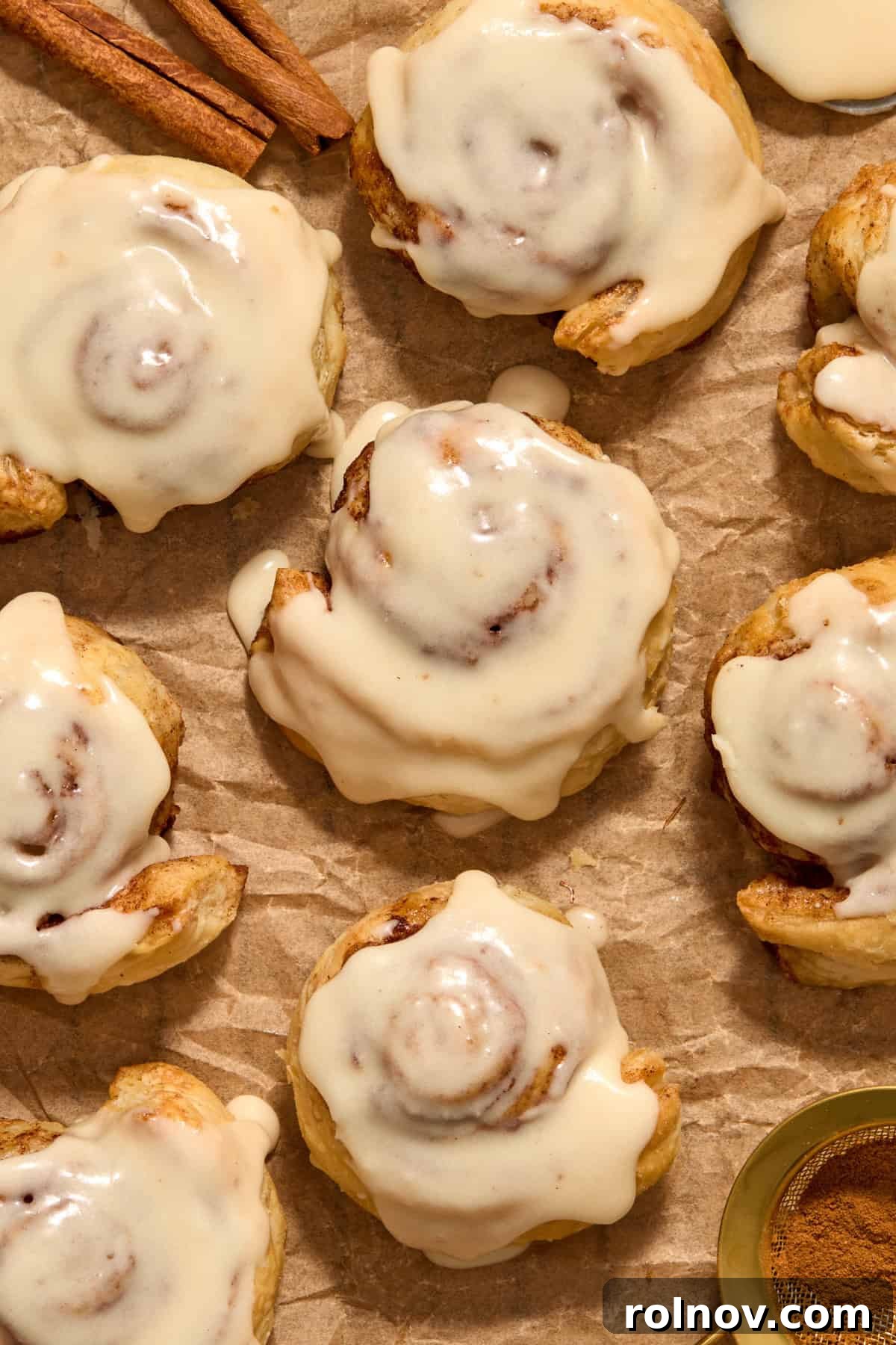 Flaky Cinnamon Swirls 12 Iced cinnamon rolls on parchment paper.
