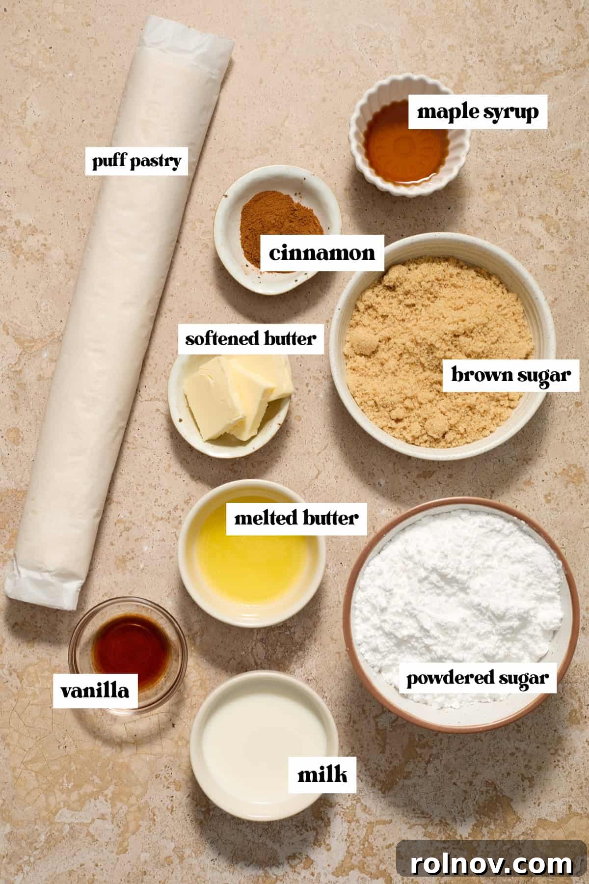 Flaky Cinnamon Swirls 3 Puff pastry roll, brown sugar, cinnamon, butter and other labeled ingredients on surface.