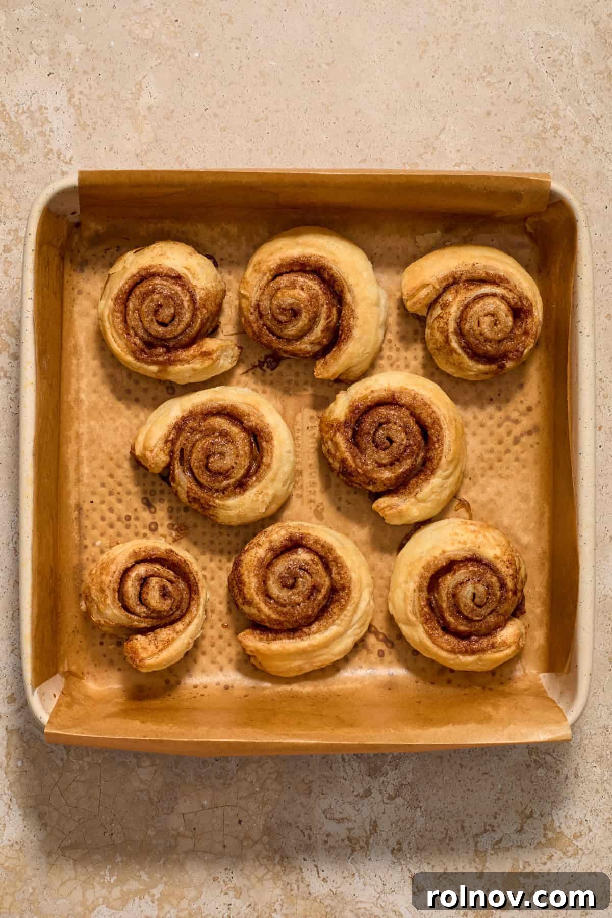 Flaky Cinnamon Swirls 10 Baked puff pastry cinnamon rolls in pan.