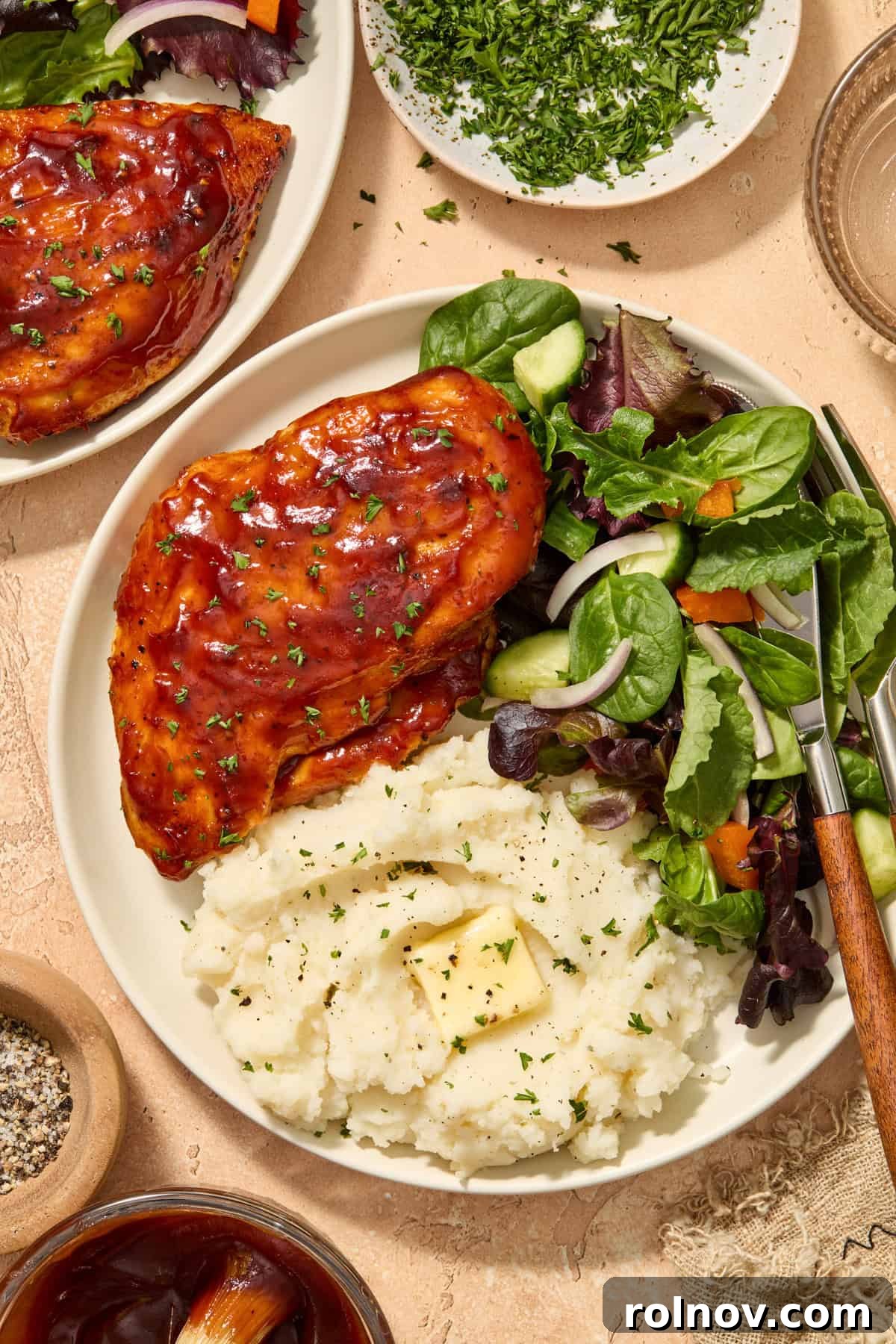 Air fryer bbq chicken breast served on plate with mashed potatoes and green salad.
