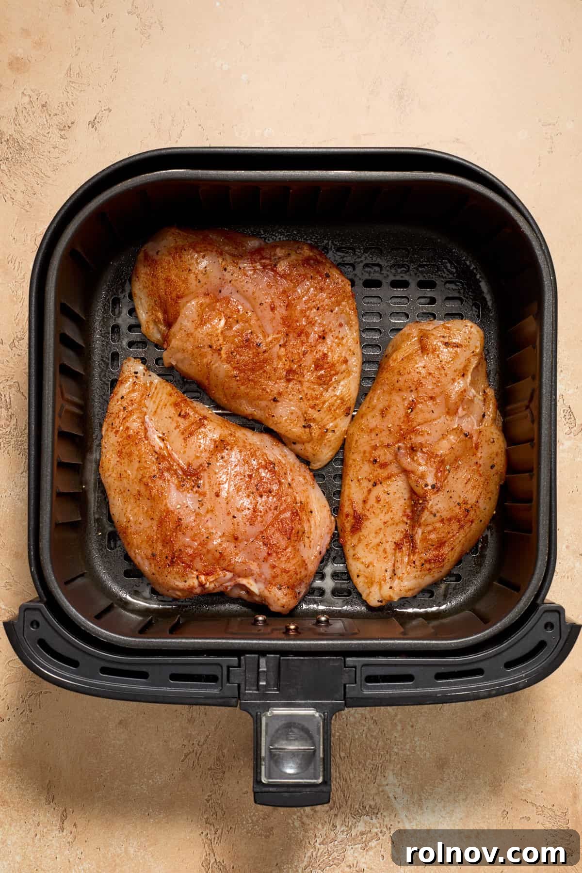 Chicken in air fryer before being cooked.