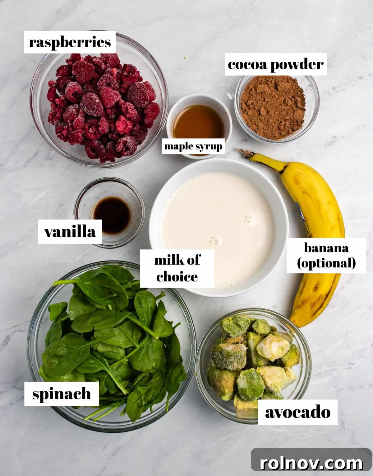 Silky Chocolate Raspberry Avocado Delight 3 Spinach, cocoa powder, avocado, banana and ingredients labeled on counter.