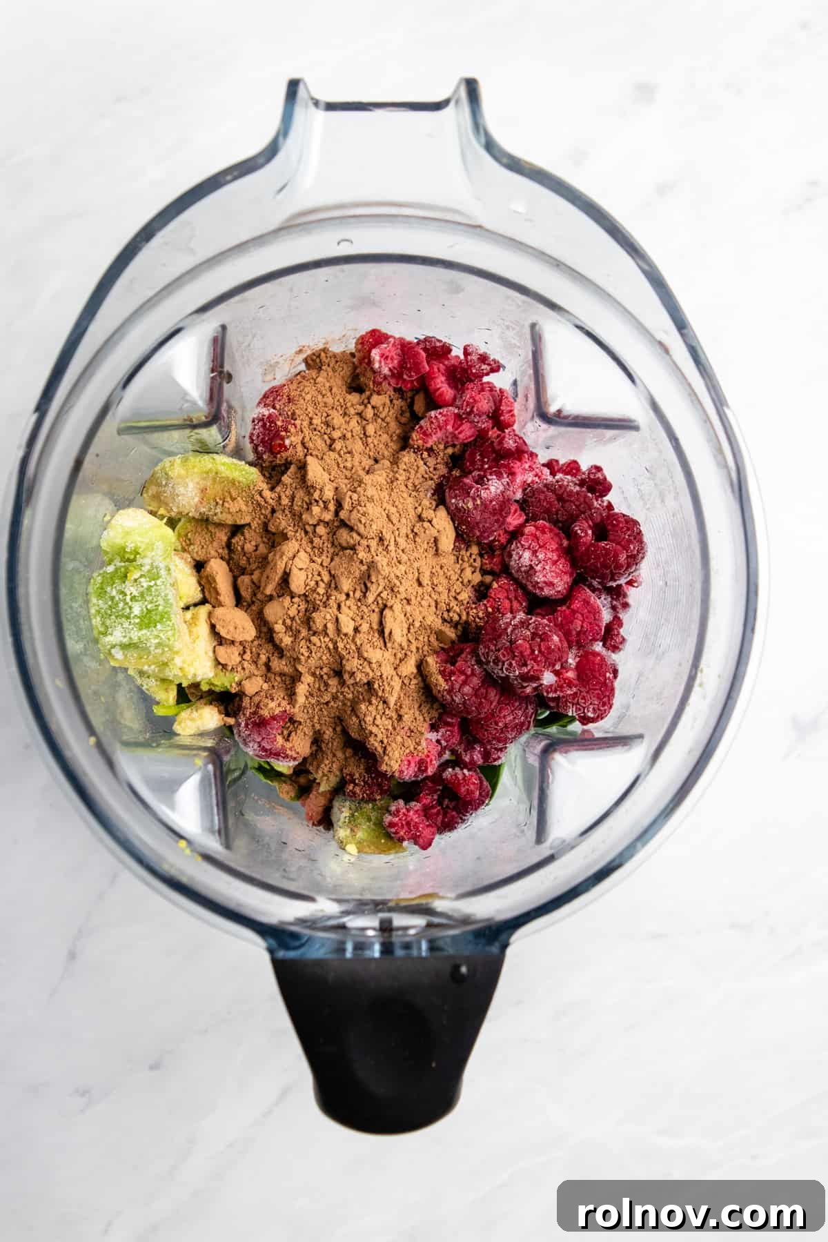 Silky Chocolate Raspberry Avocado Delight 4 Overhead view of blender with avocado, raspberries, cocoa powder etc.