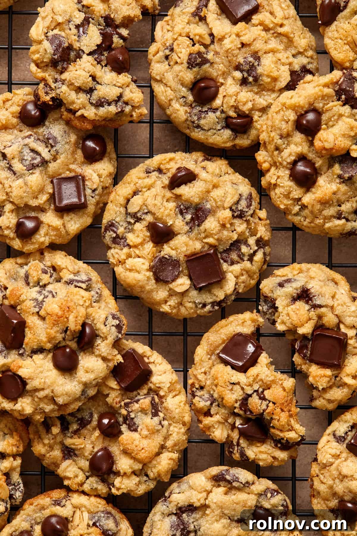 Almond & Oat Harmony Gluten-Free Chip Cookies 2 Wire rack with almond flour oatmeal chocolate chip cookies arranged in an even layer, fresh from the oven and glistening with melted chocolate.