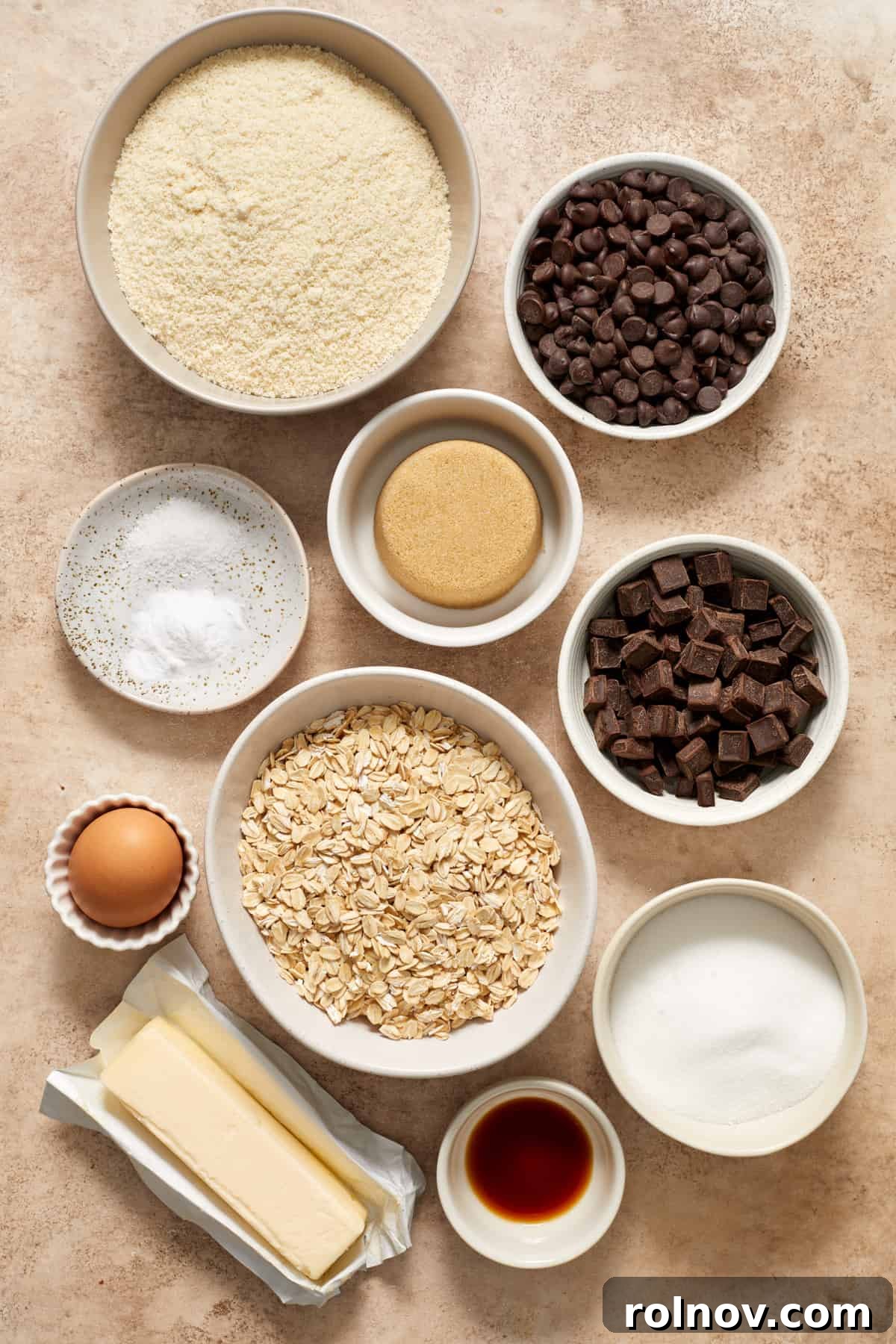 Almond & Oat Harmony Gluten-Free Chip Cookies 4 Rolled oats, almond flour, butter, egg, and other cookie ingredients are carefully arranged on a clean surface, prepped and ready for baking.