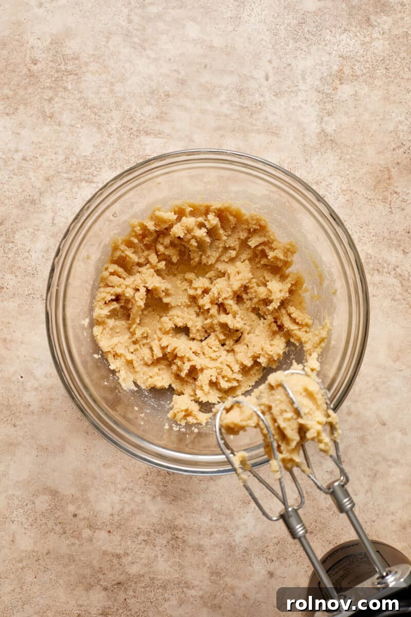 Almond & Oat Harmony Gluten-Free Chip Cookies 5 Creamed butter and sugar in a mixing bowl with an electric mixer nearby, ready for the next step.