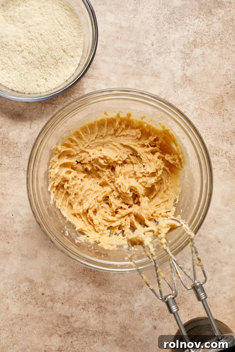 Almond & Oat Harmony Gluten-Free Chip Cookies 6 Mixing bowl with creamed butter, sugar, egg, and vanilla, alongside a bowl of almond flour, perfectly measured and waiting to be combined.