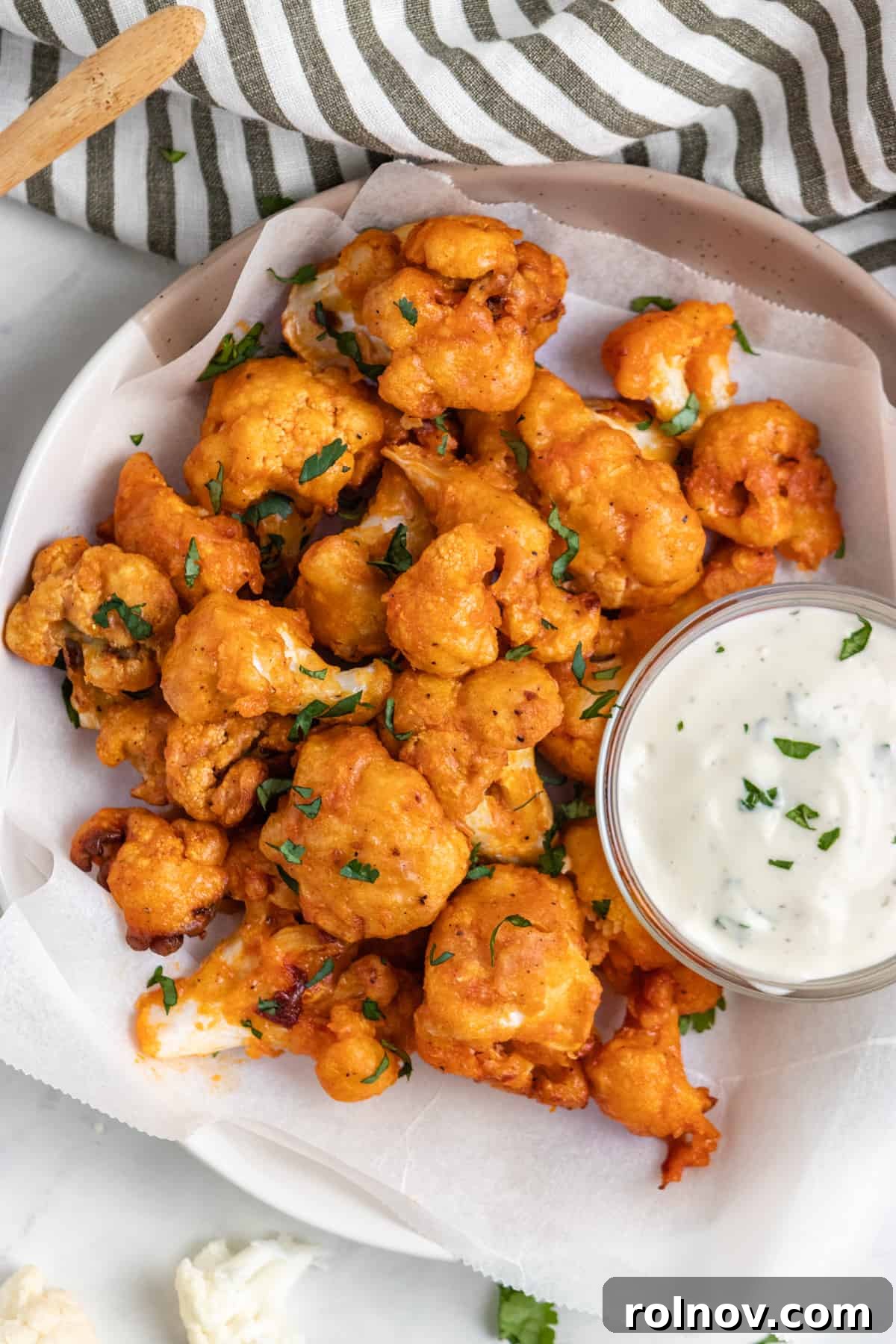 Zesty Air-Fried Buffalo Cauliflower 7 Overhead view of air fryer buffalo cauliflower with dip.