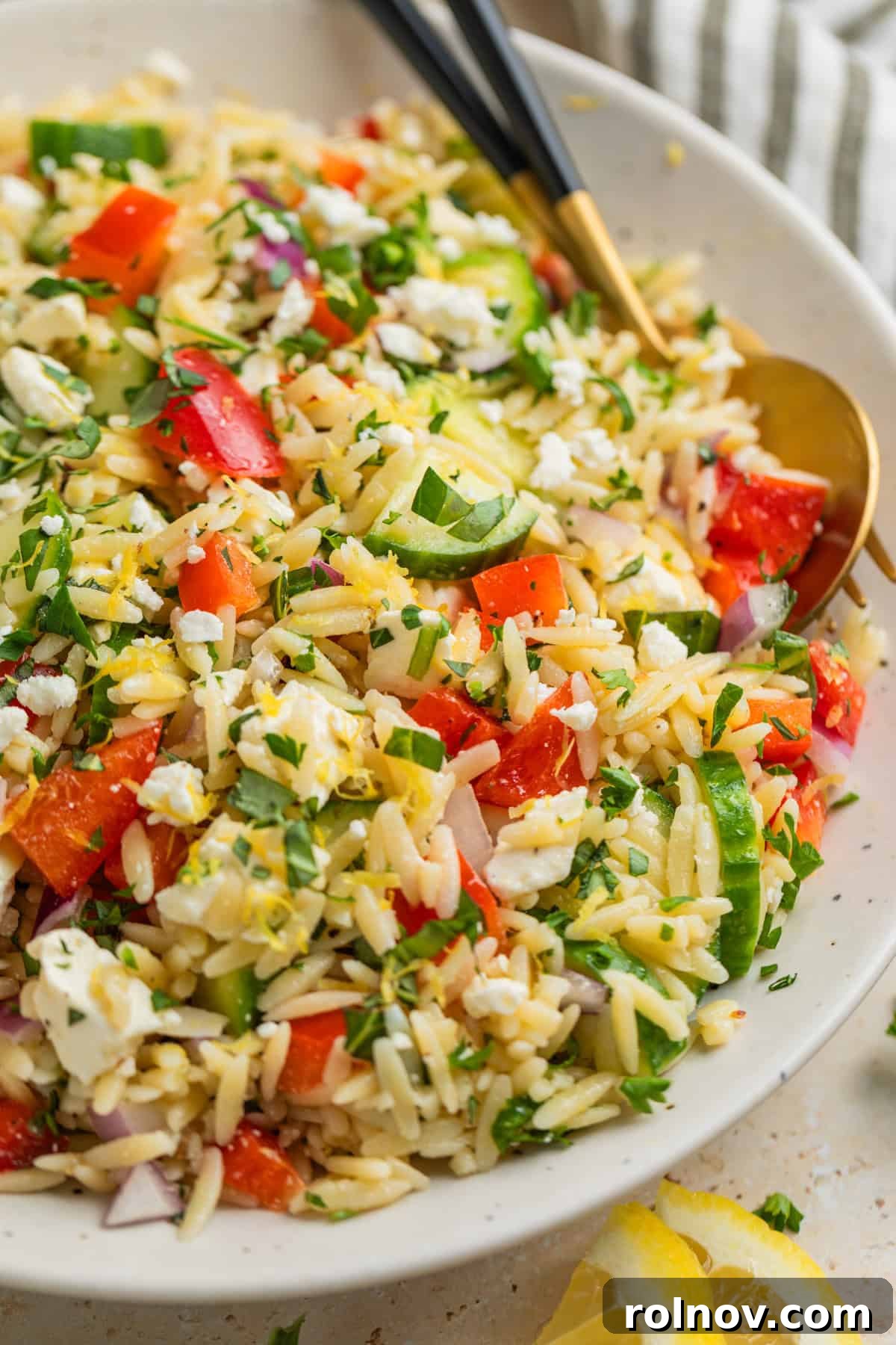 Bright & Effortless Lemon Orzo Salad with Feta 3 Lemon orzo salad with feta, garnished with fresh herbs in a white bowl.