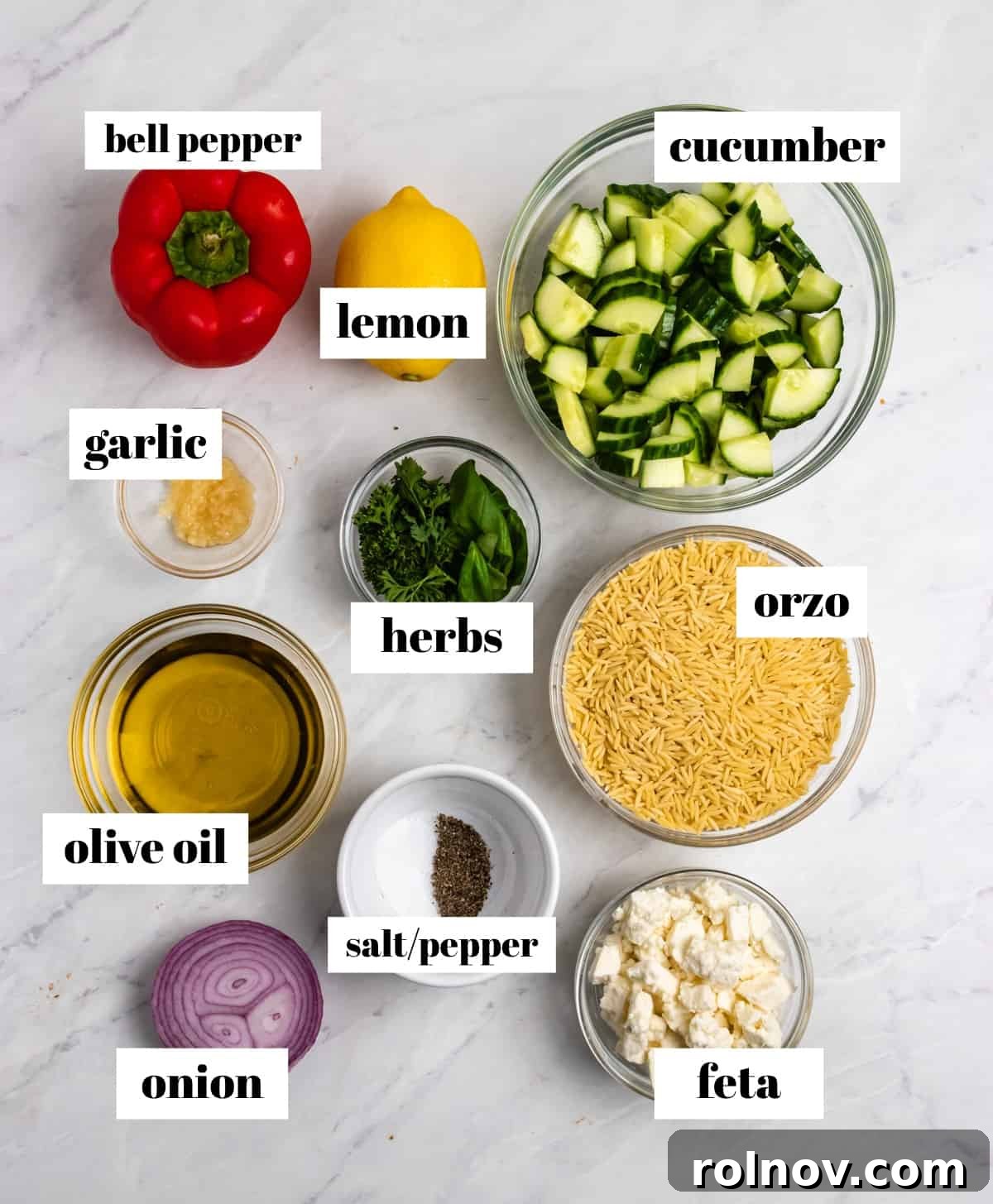 Bright & Effortless Lemon Orzo Salad with Feta 4 Cucumber, pepper, orzo, lemon, onion and other ingredients labeled on counter, ready for assembly.