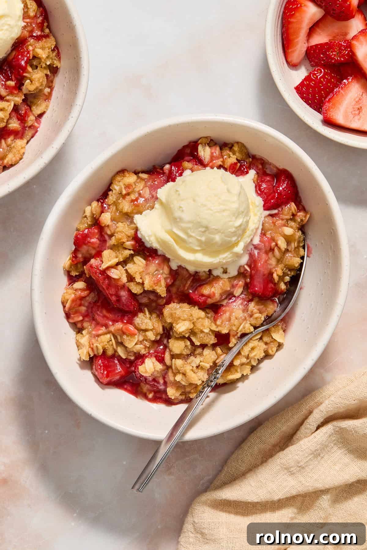 Crimson Crumble Dream 2 White dish with serving of strawberry crumble topped with vanilla ice cream.