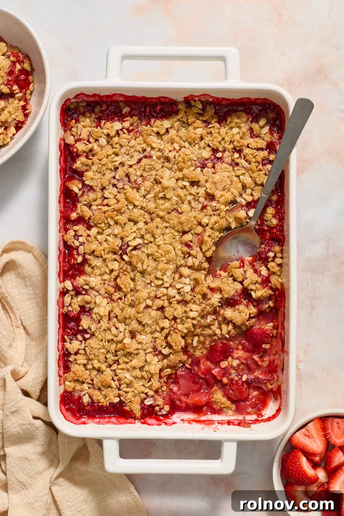 Crimson Crumble Dream 11 Overhead view of strawberry crumble in pan with spoon inside.