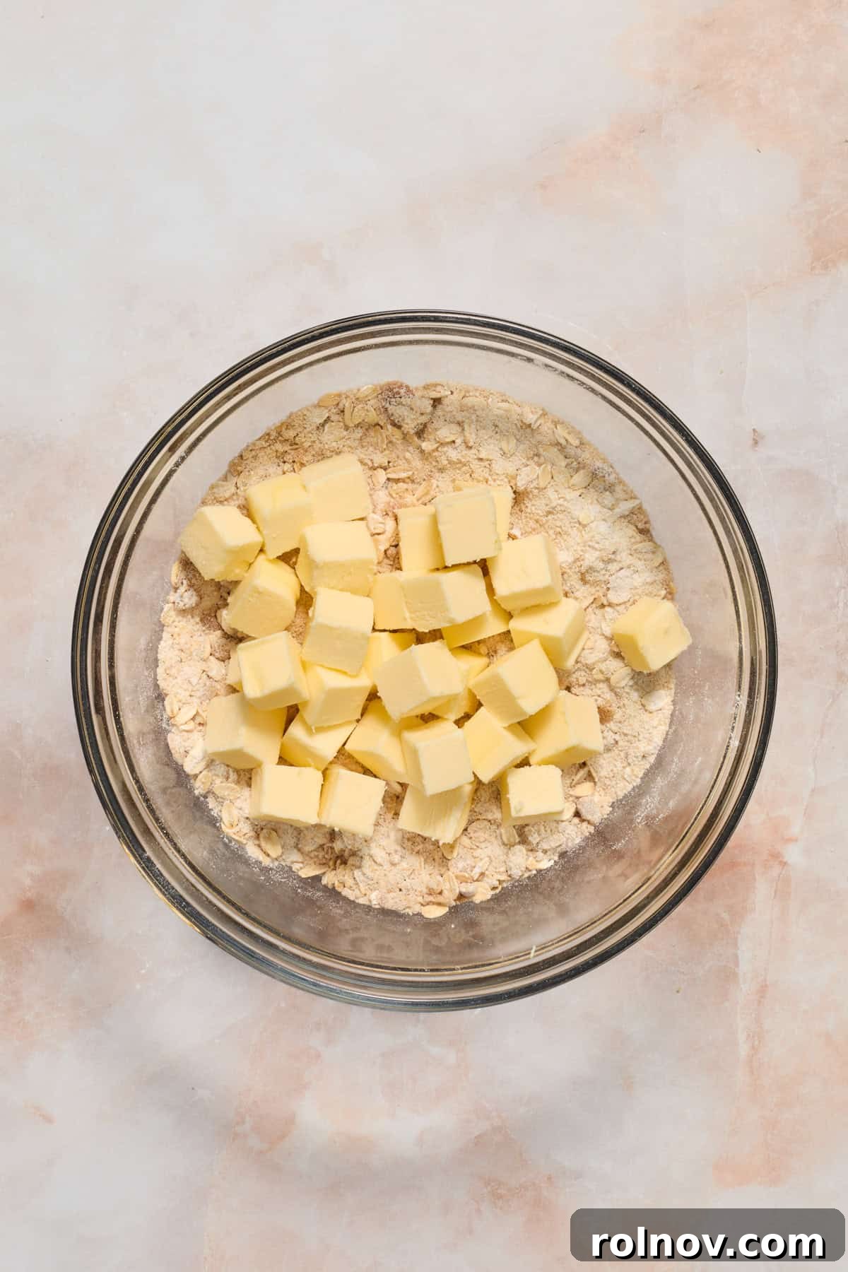 Crimson Crumble Dream 6 Butter cubes added to bowl with crumble oat mixture.