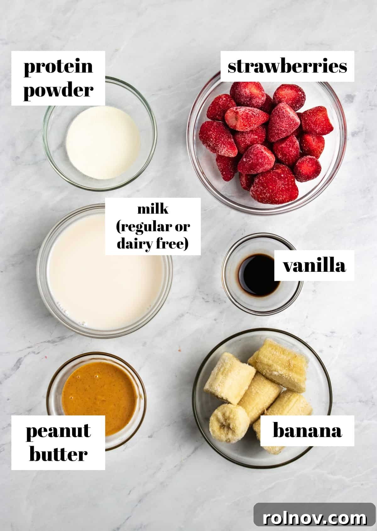Strawberry Nut Bliss Smoothie 3 Peanut butter, banana, strawberries, vanilla and ingredients labeled on counter.