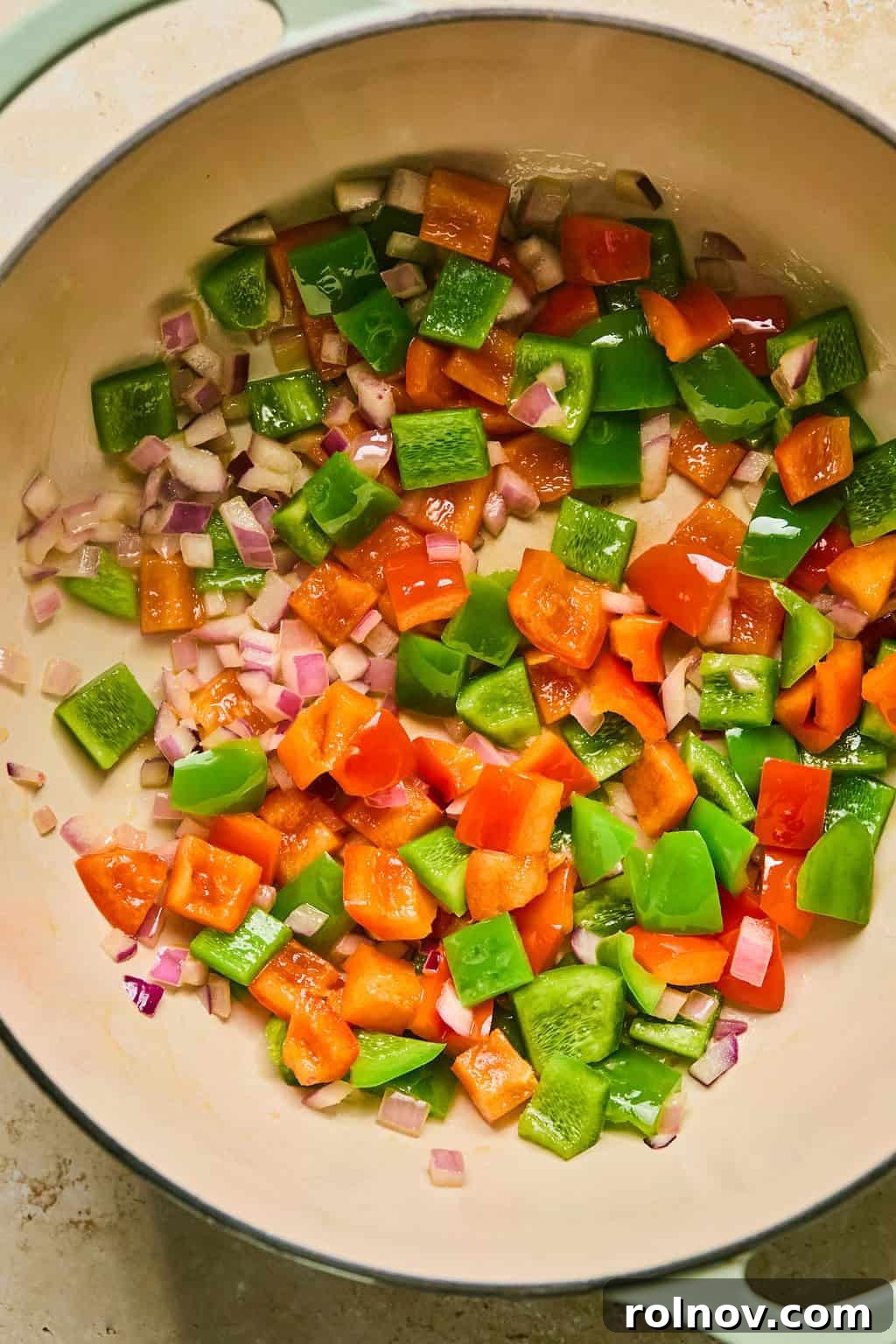 Sautéed onions and bell peppers, now soft and fragrant, resting in the pot after cooking.