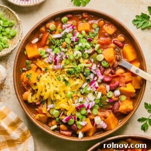 Overhead view of bowl with butternut squash chili with spoon scooping into the bowl.