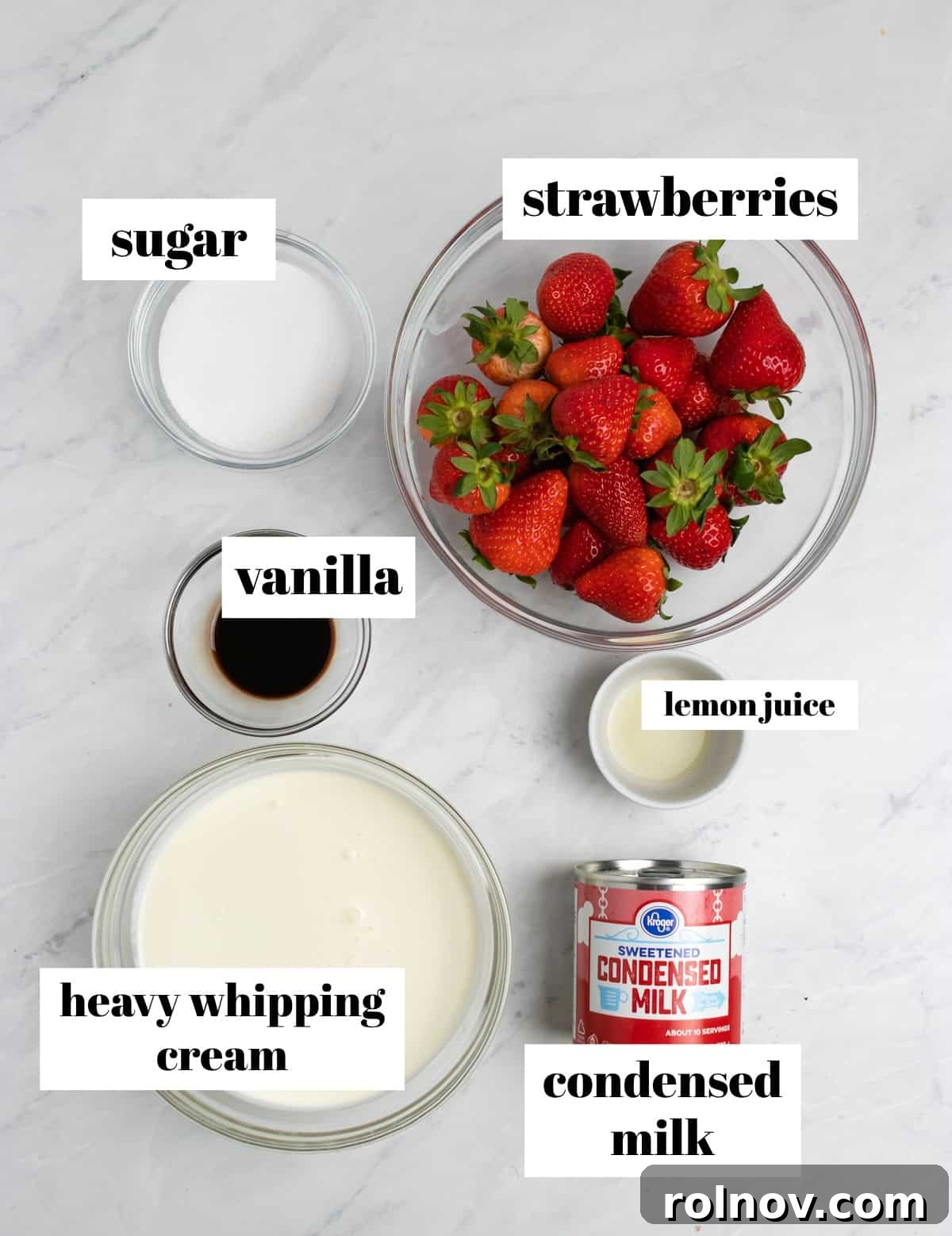 Easy Homemade No-Churn Strawberry Delight 3 All the fresh ingredients for no-churn strawberry ice cream, including whole strawberries, heavy cream, sweetened condensed milk, sugar, vanilla extract, and a lemon, neatly displayed on a kitchen counter.