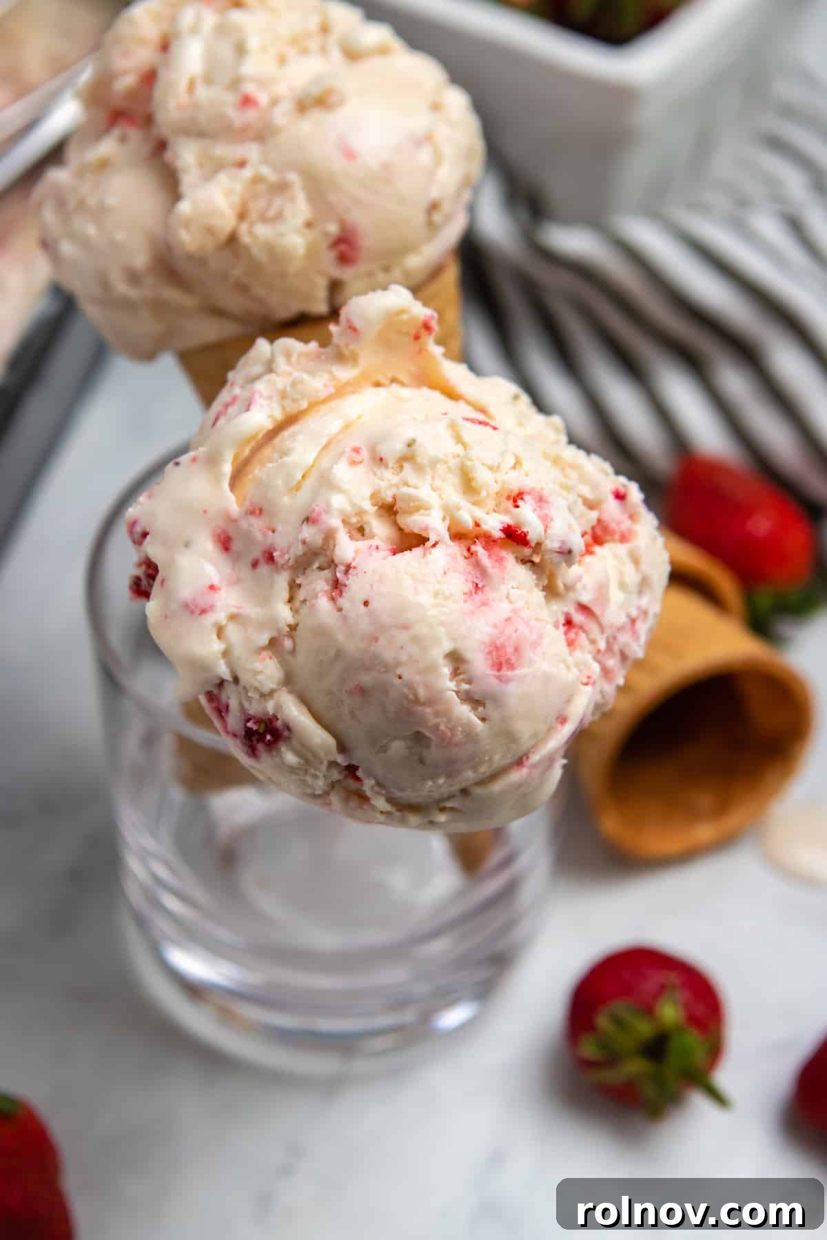 Easy Homemade No-Churn Strawberry Delight 6 Crisp, golden sugar ice cream cones arranged artfully in a clear glass cup, patiently waiting to be filled with the delicious homemade no-churn strawberry ice cream.