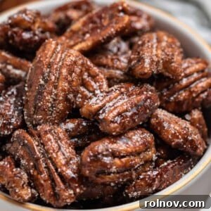 Sugar dusted maple pecans in a decorative ceramic bowl, showcasing their sweet crunch and festive appearance.