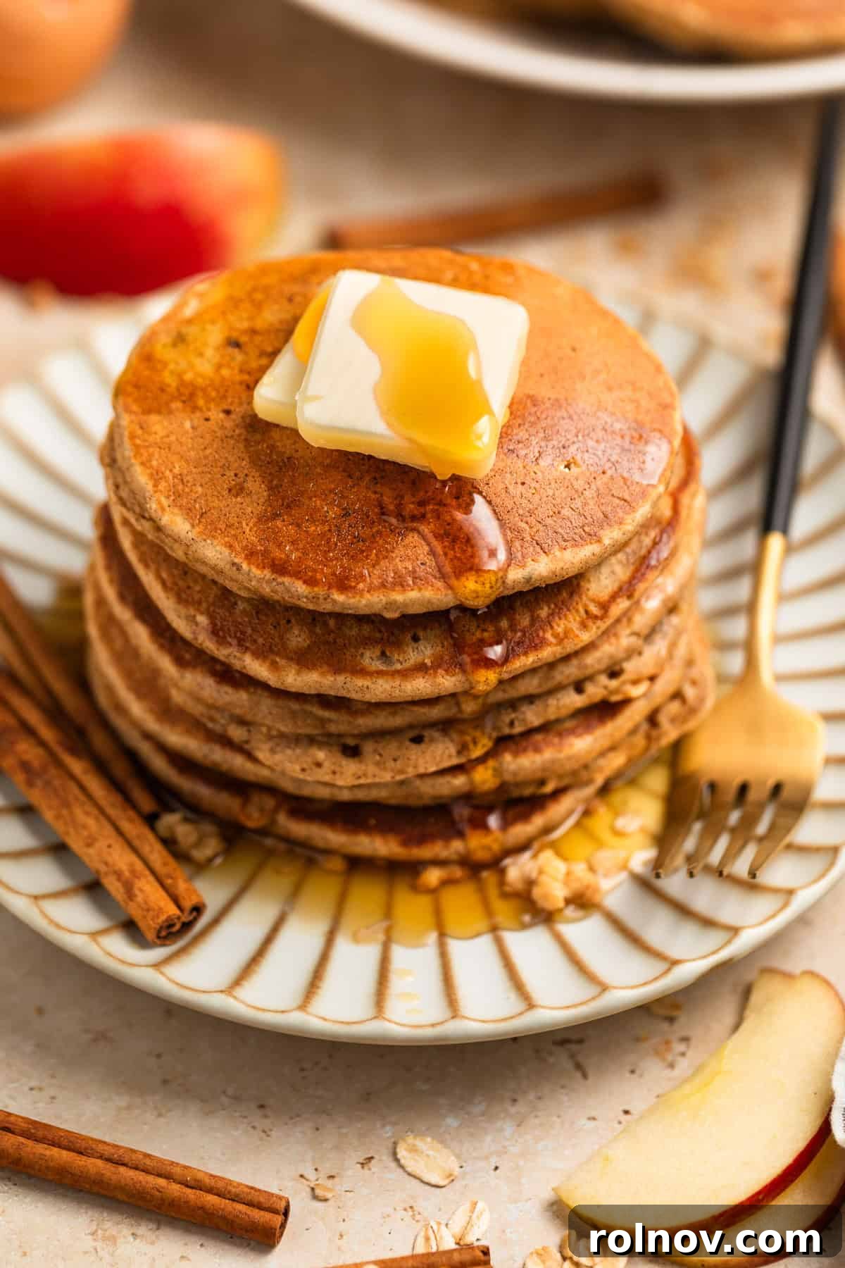 Spiced Apple Oat Pancakes 2 Stack of apple oatmeal pancakes on plate topped with butter and syrup, ready to be enjoyed.