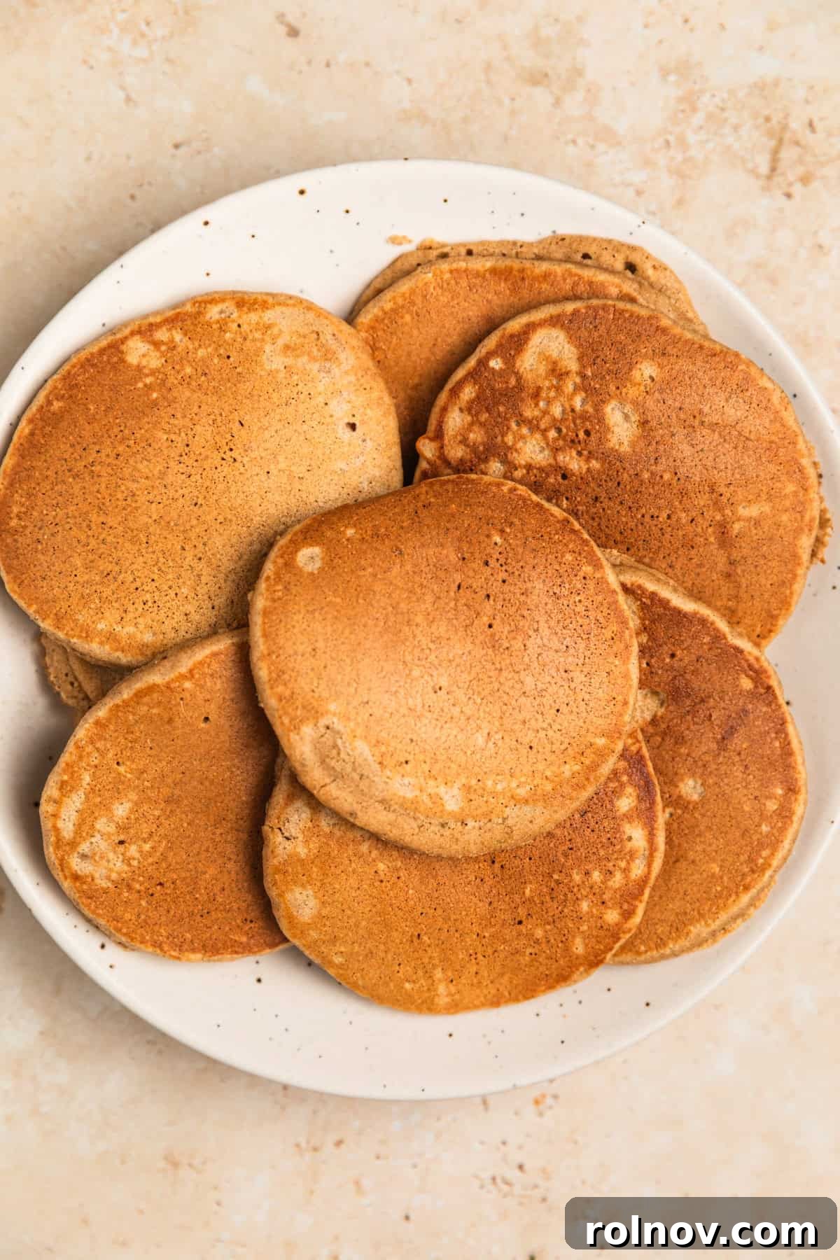 Spiced Apple Oat Pancakes 11 Several golden brown apple oat pancakes cooking on a hot griddle.
