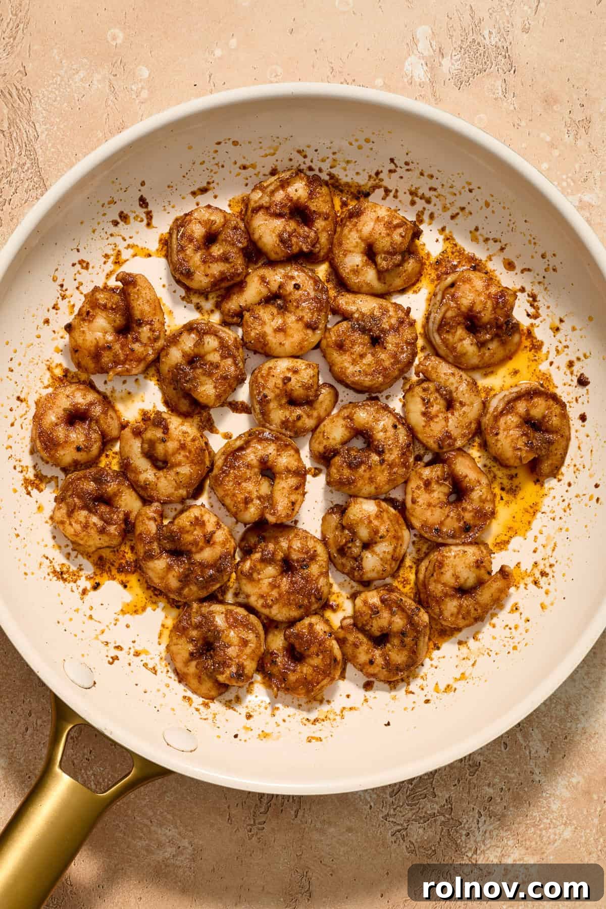Tropical Shrimp Tacos with Mango Salsa 12 Perfectly cooked shrimp, glistening and tender, arranged in a skillet, ready to be used in tacos.