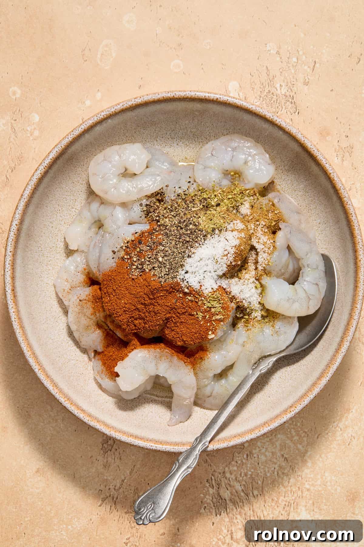 Tropical Shrimp Tacos with Mango Salsa 5 Raw shrimp in a bowl, coated with chili powder, garlic powder, and other seasonings, ready for marination.