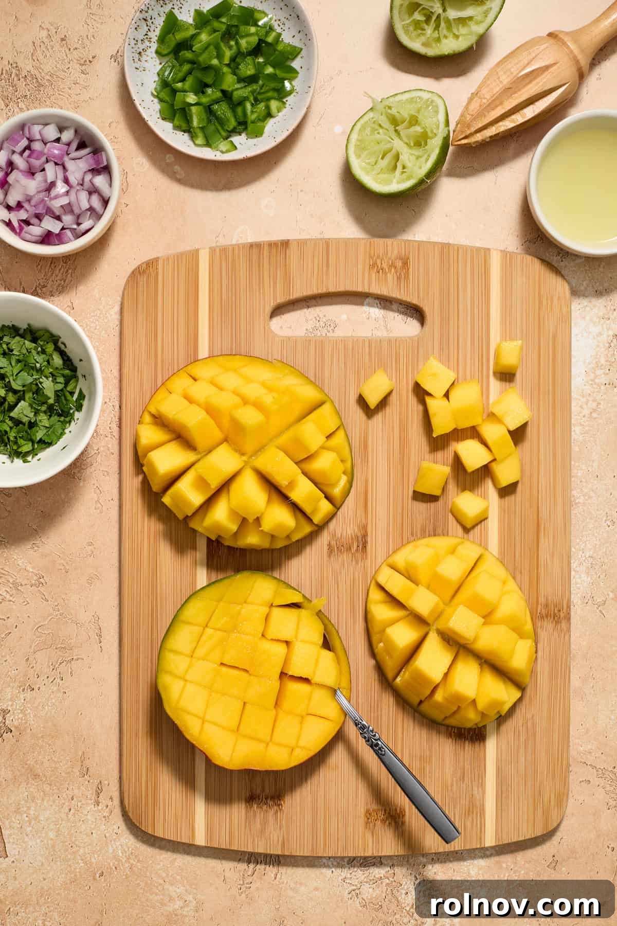 Tropical Shrimp Tacos with Mango Salsa 7 Diced mangoes on a cutting board, surrounded by a freshly juiced lime, chopped red onion, and other vibrant salsa ingredients.