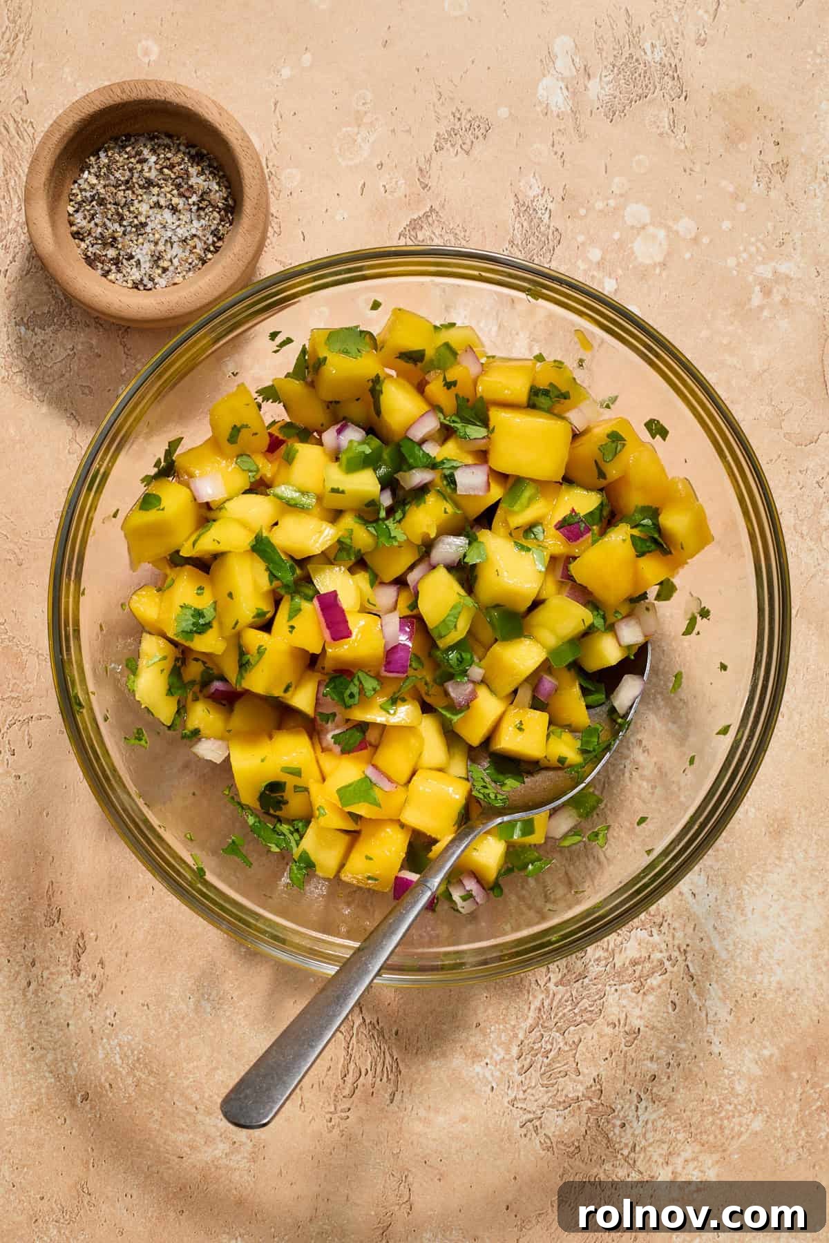 Tropical Shrimp Tacos with Mango Salsa 9 Freshly prepared mango salsa in a bowl, with salt and pepper shakers beside it, ready for seasoning.