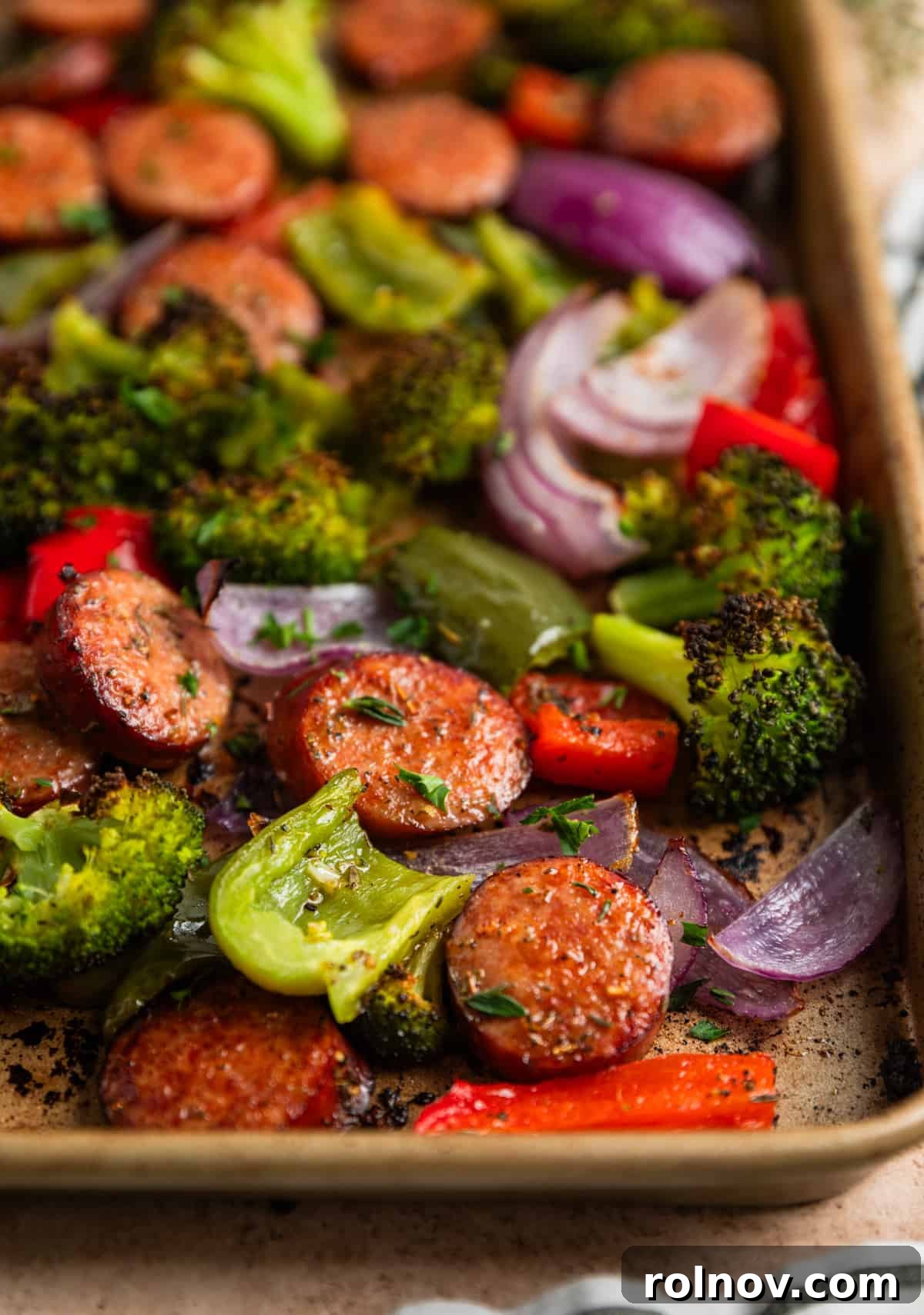 Roasted Sausage & Veggie Sheet Pan Supper 7 Sausages and vegetables cooked on sheet pan topped with fresh thyme and chopped parsley.