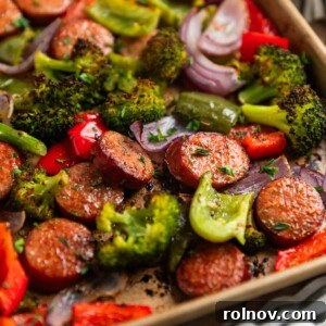 Roasted Sausage & Veggie Sheet Pan Supper 8 Sausages and peppers with broccoli on sheet pan after being cooked.