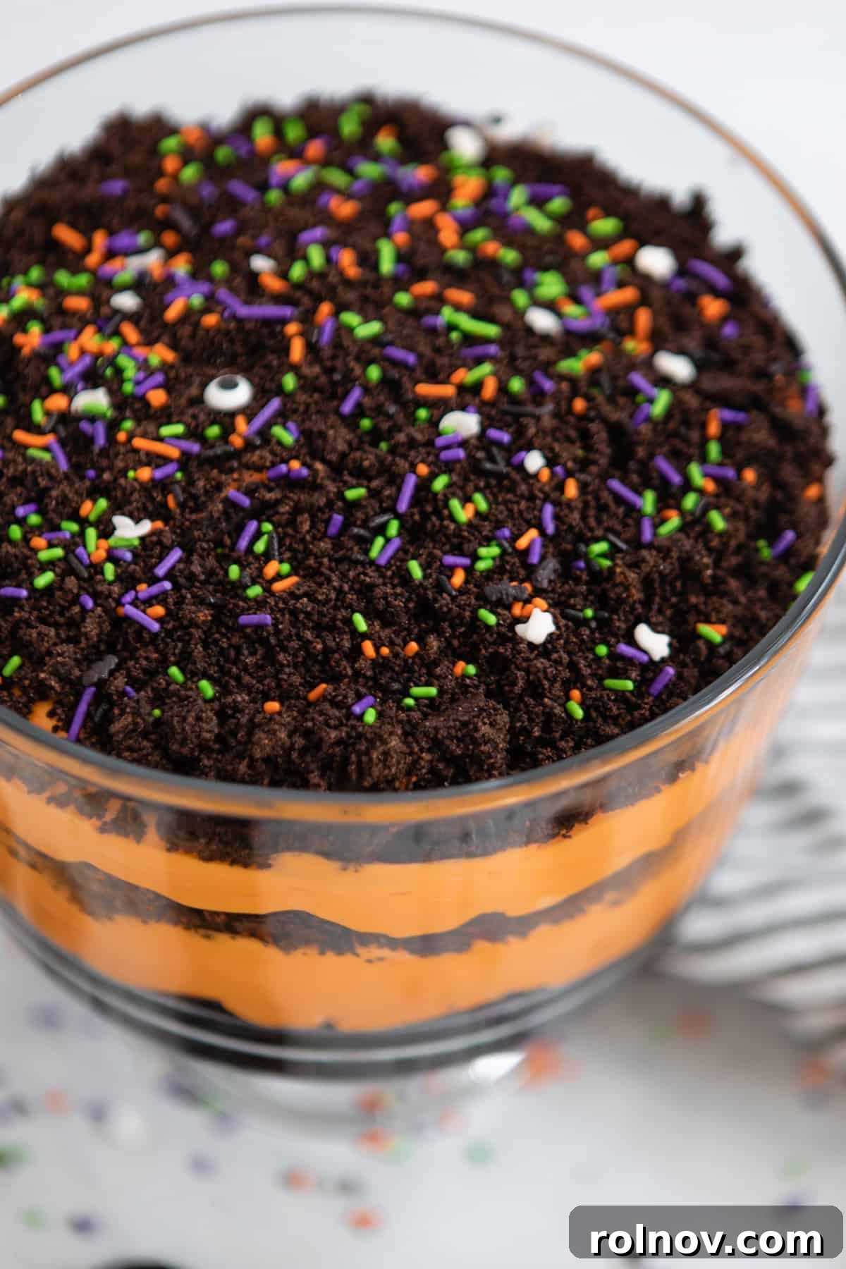 Halloween Oreo Graveyard Cake 6 Trifle bowl with layered orange pudding and crushed Halloween Oreos.