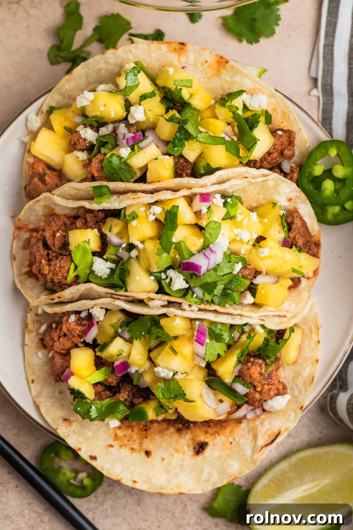 Zesty Pork Tacos with Fresh Pineapple Salsa 2 Overhead view of ground pork tacos topped with pineapple salsa.