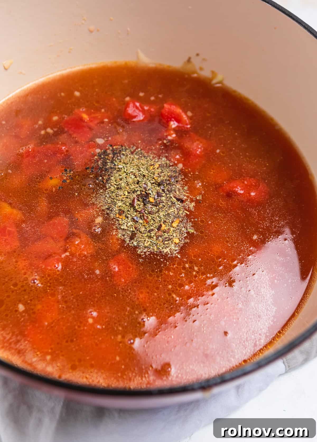 Hearty Sausage and Gnocchi Soup 5 Pot with broth, tomatoes and seasonings added over top.