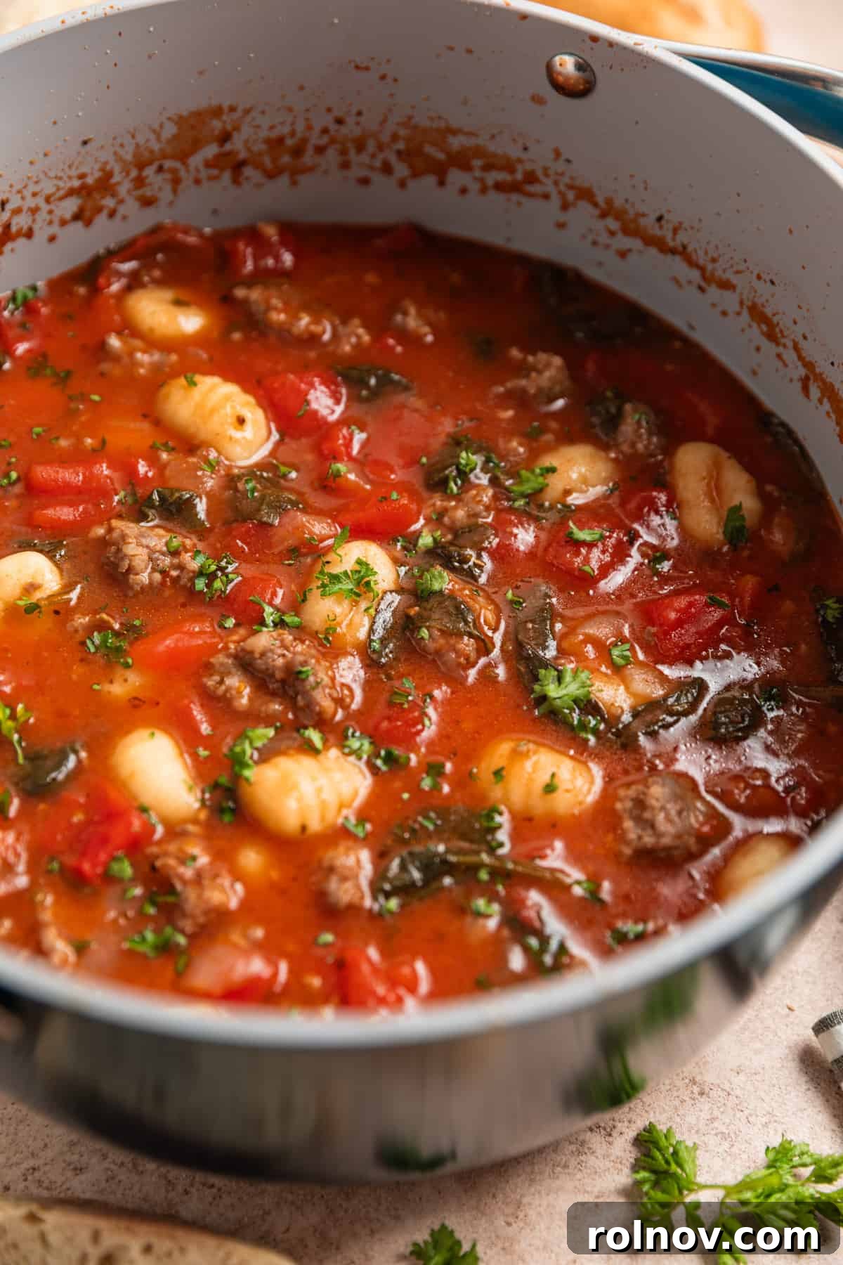 Hearty Sausage and Gnocchi Soup 6 Pot with sausage and gnocchi soup topped with parsley.