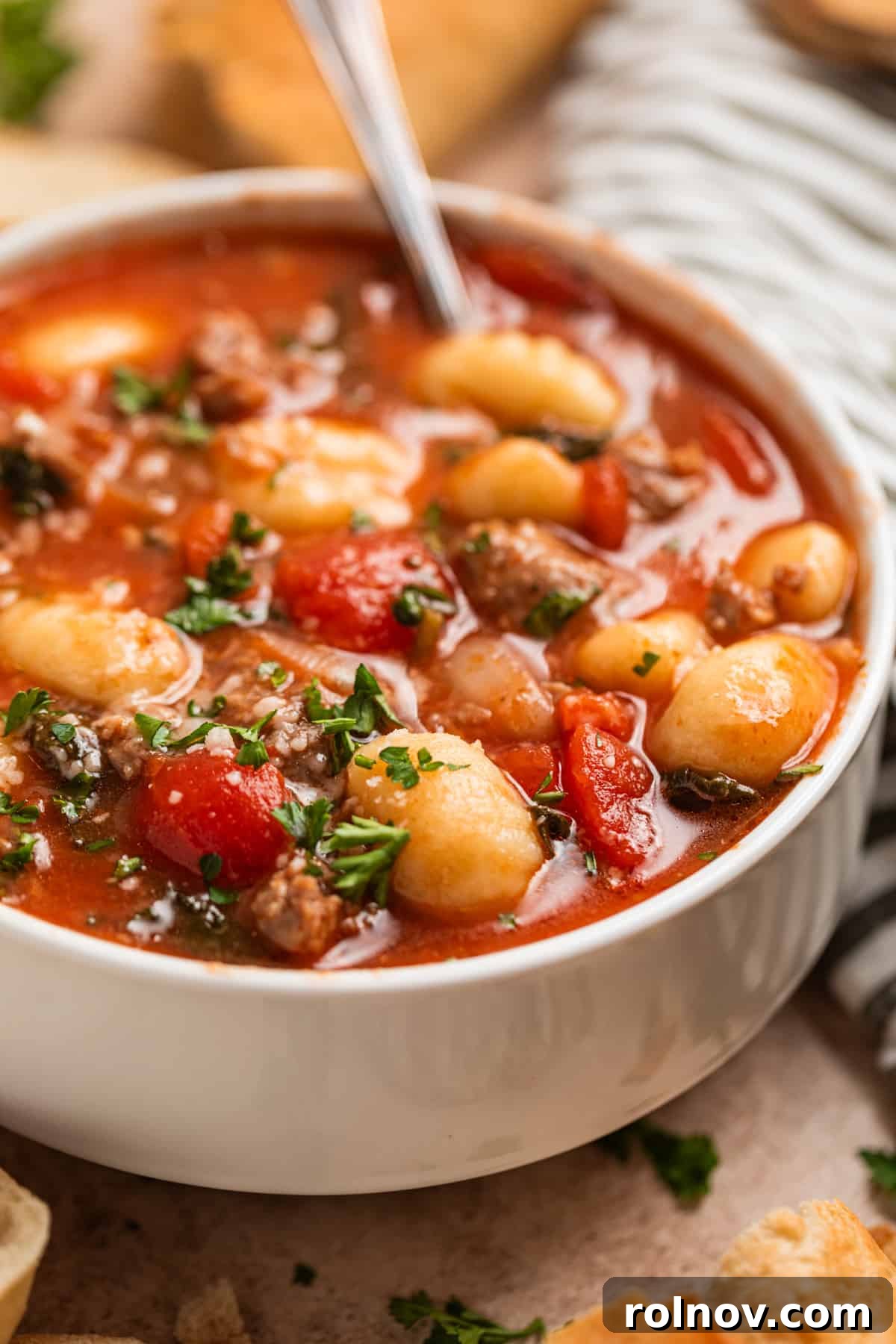 Hearty Sausage and Gnocchi Soup 7 Bowl of sausage gnocchi soup topped with parsley and grated parmesan.