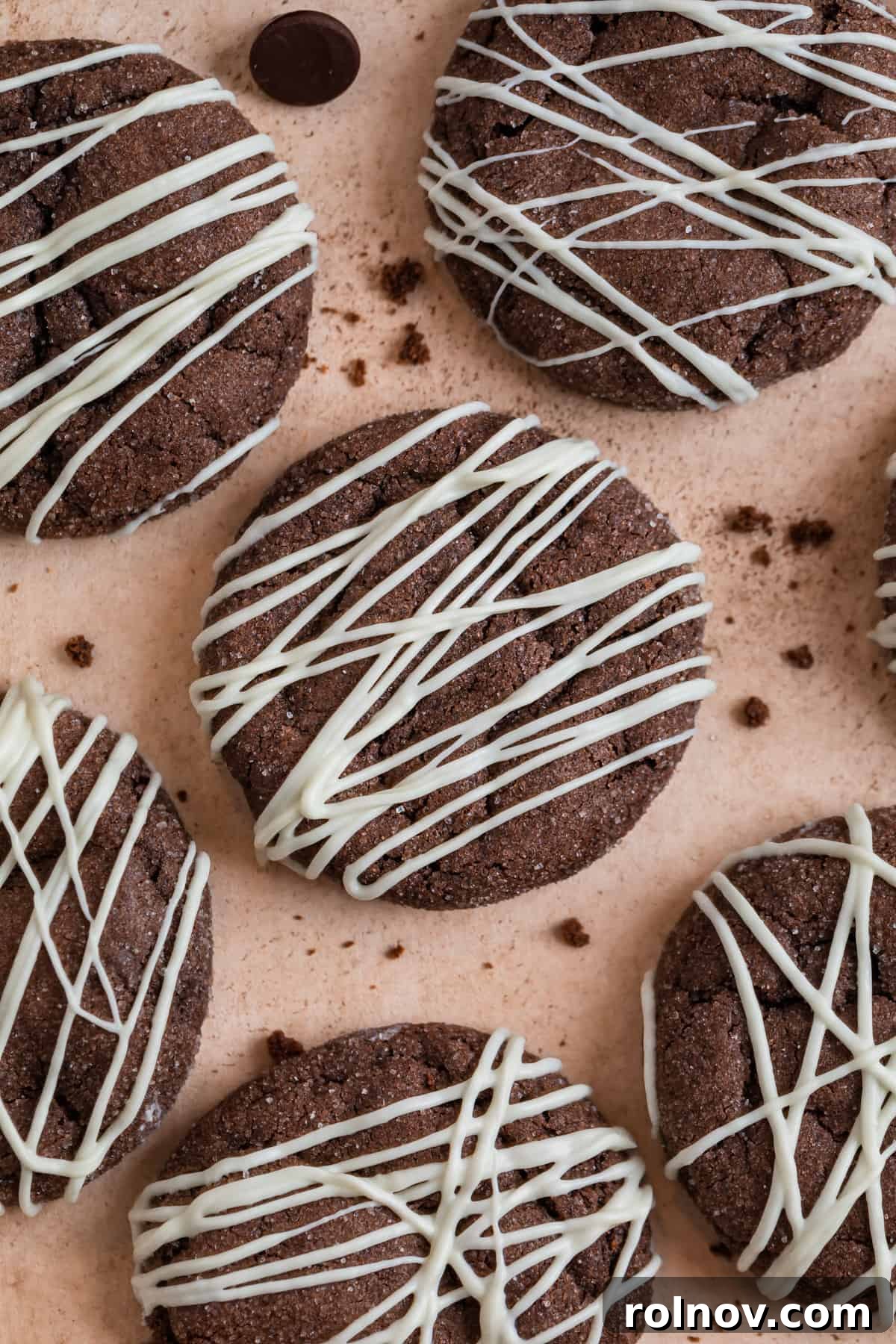 Effortless Chocolate Cake Mix Treats 2 Decadent chocolate cake mix cookies, artfully drizzled with white chocolate, invitingly displayed on a kitchen counter.