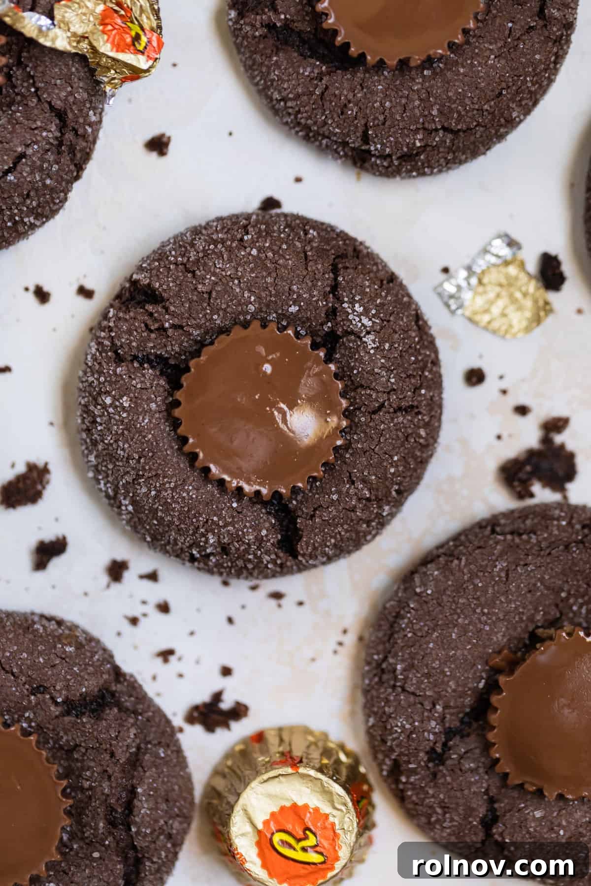Effortless Chocolate Cake Mix Treats 11 An overhead perspective showcasing fudgy chocolate cake mix cookies, each featuring a delightful peanut butter cup nestled perfectly in its center, on a light background.