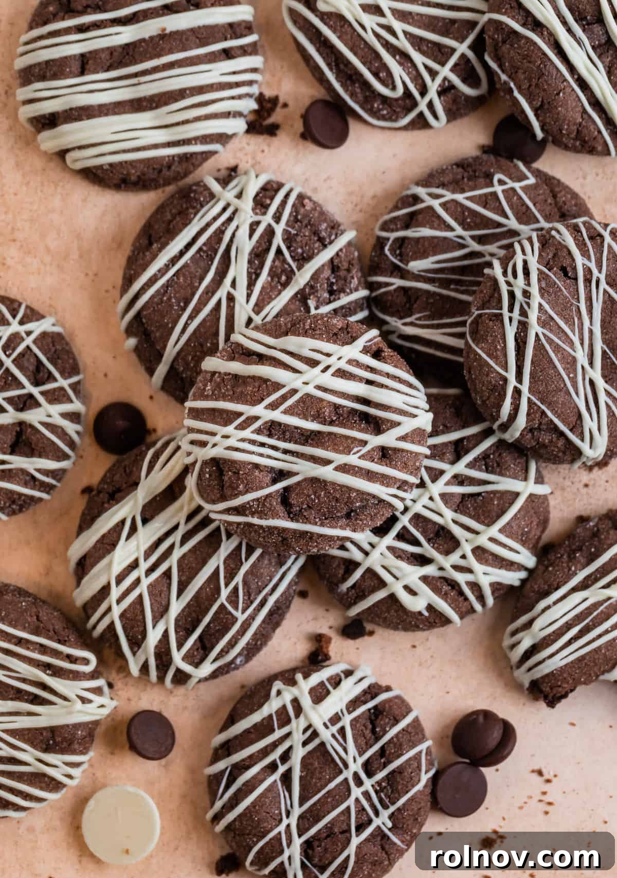 Effortless Chocolate Cake Mix Treats 12 Rows of warm chocolate cake mix cookies, each elegantly drizzled with sweet white chocolate, presented on a clean kitchen counter.