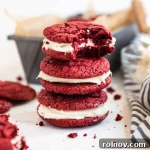 Scarlet Velvet Cake Mix Cookies with Tangy Cream Cheese Frosting 9 Stack of red velvet cake mix cookies with bite taken out of top cookie, showing the creamy filling.