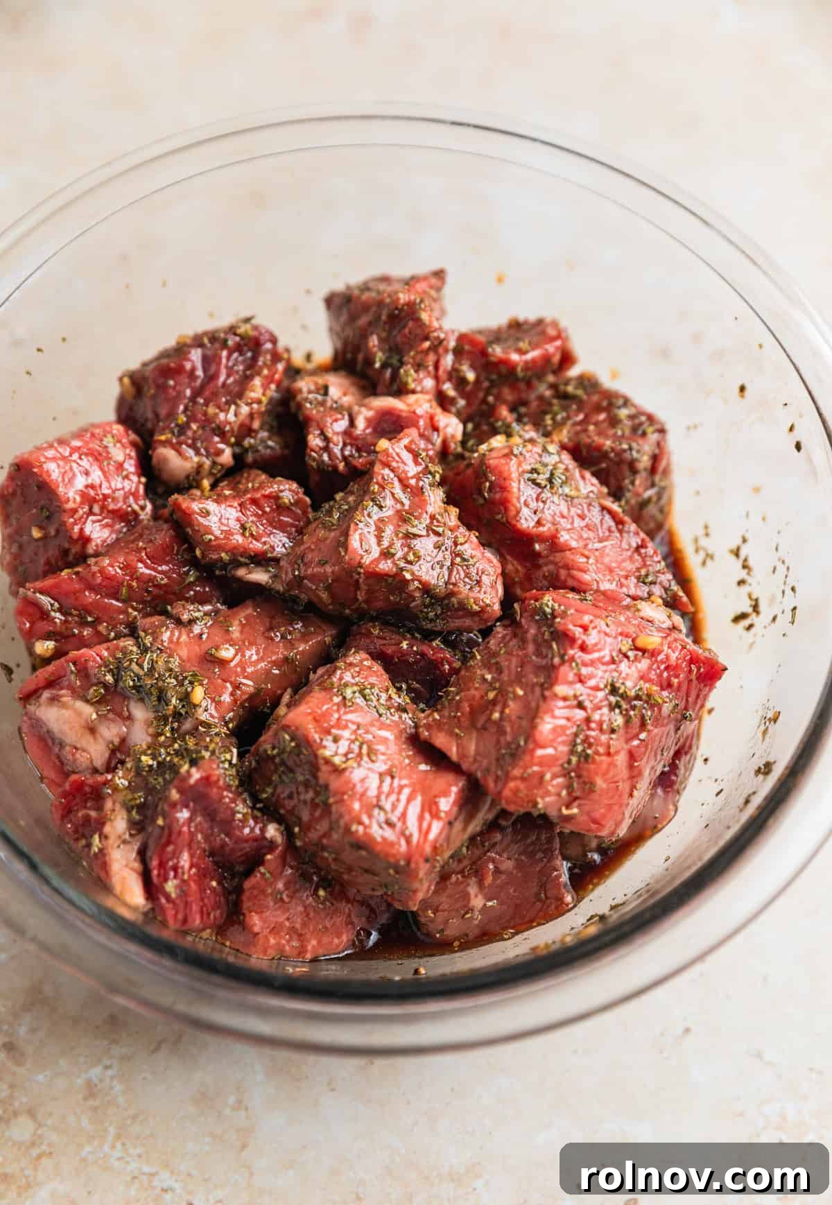 Succulent Air Fryer Steak Bites 6 Steak bites in glass mixing bowl tossed with marinade.