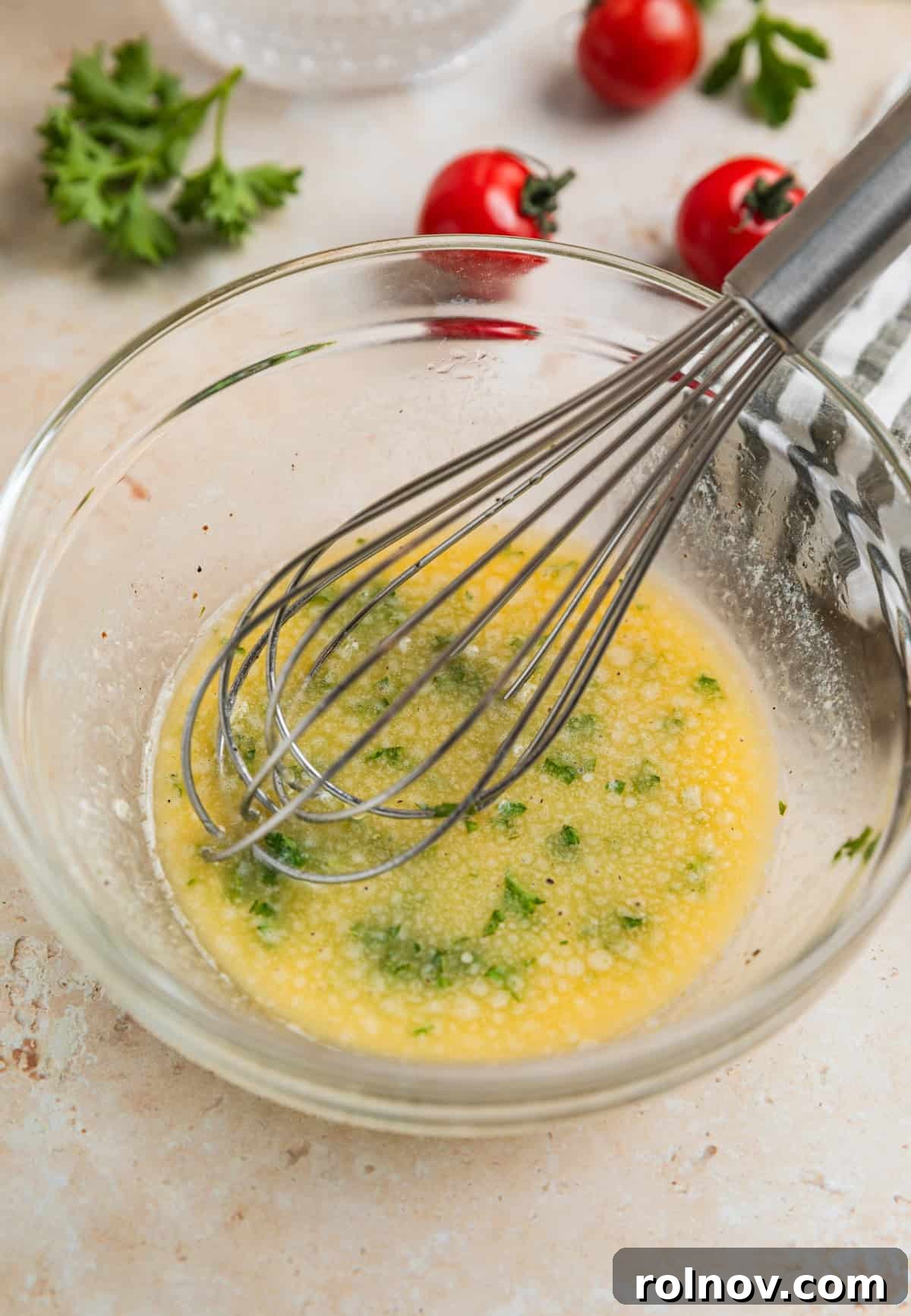 Succulent Air Fryer Steak Bites 9 Lemon garlic butter sauce in glass bowl with whisk.